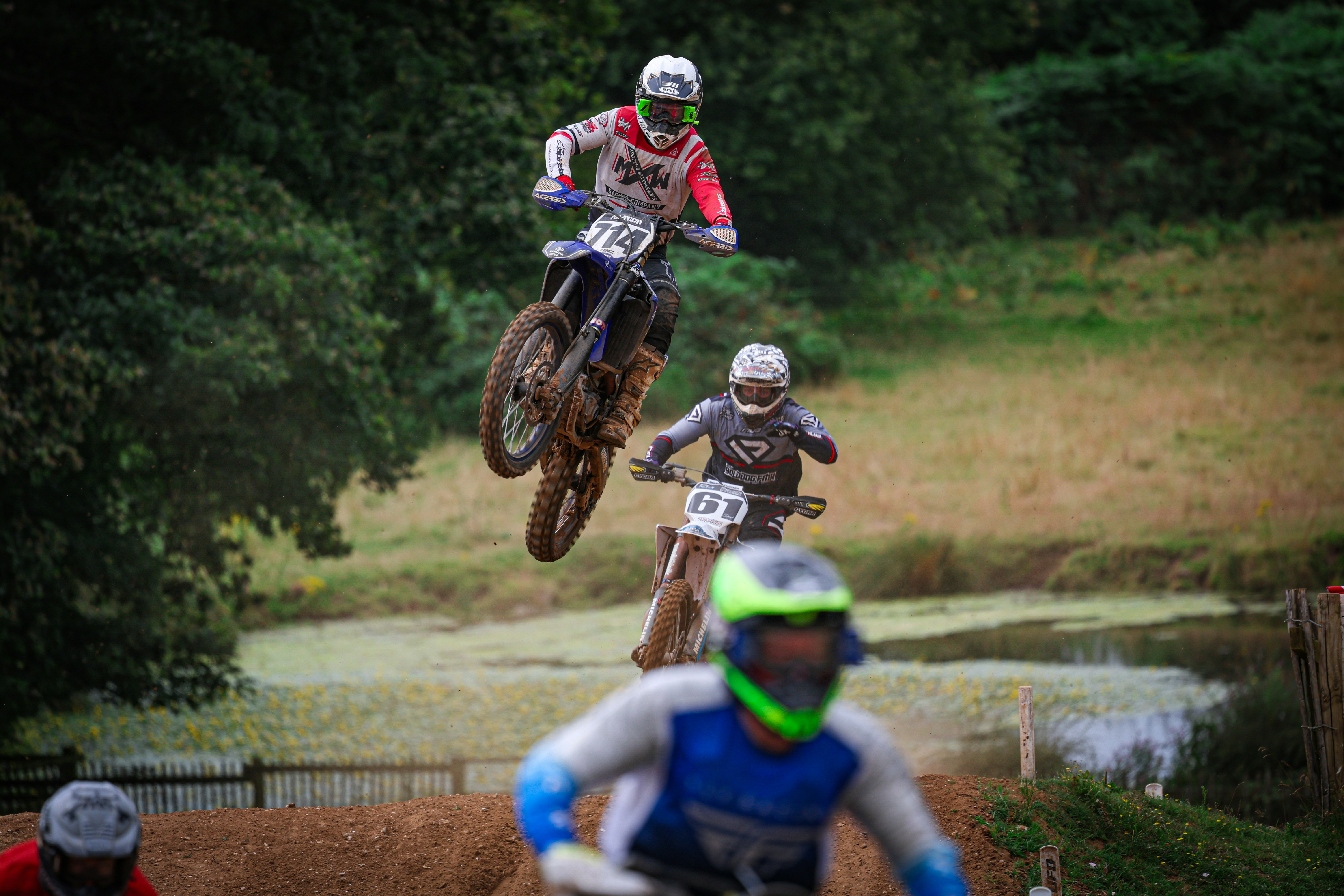 A group of people riding dirt bikes on top of a dirt field