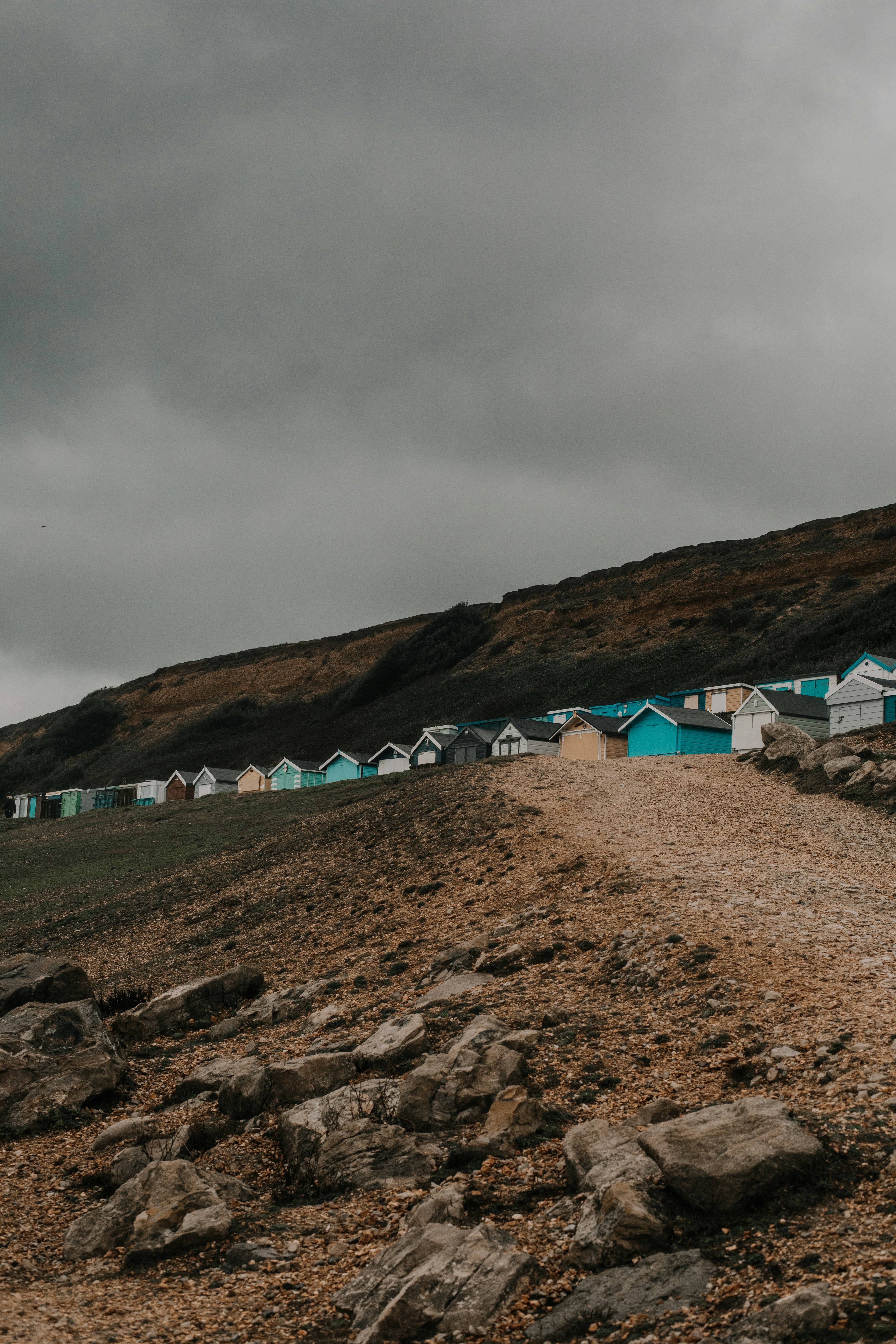 Uma estrada de terra que conduz a uma fileira de cabanas de praia