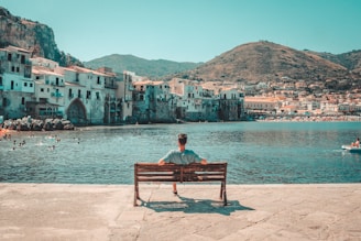 A person sitting on a bench looking out over a body of water