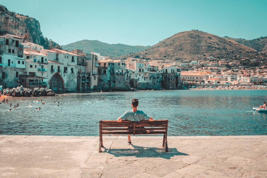 A person sitting on a bench looking out over a body of water