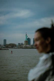 A woman standing in front of the statue of liberty