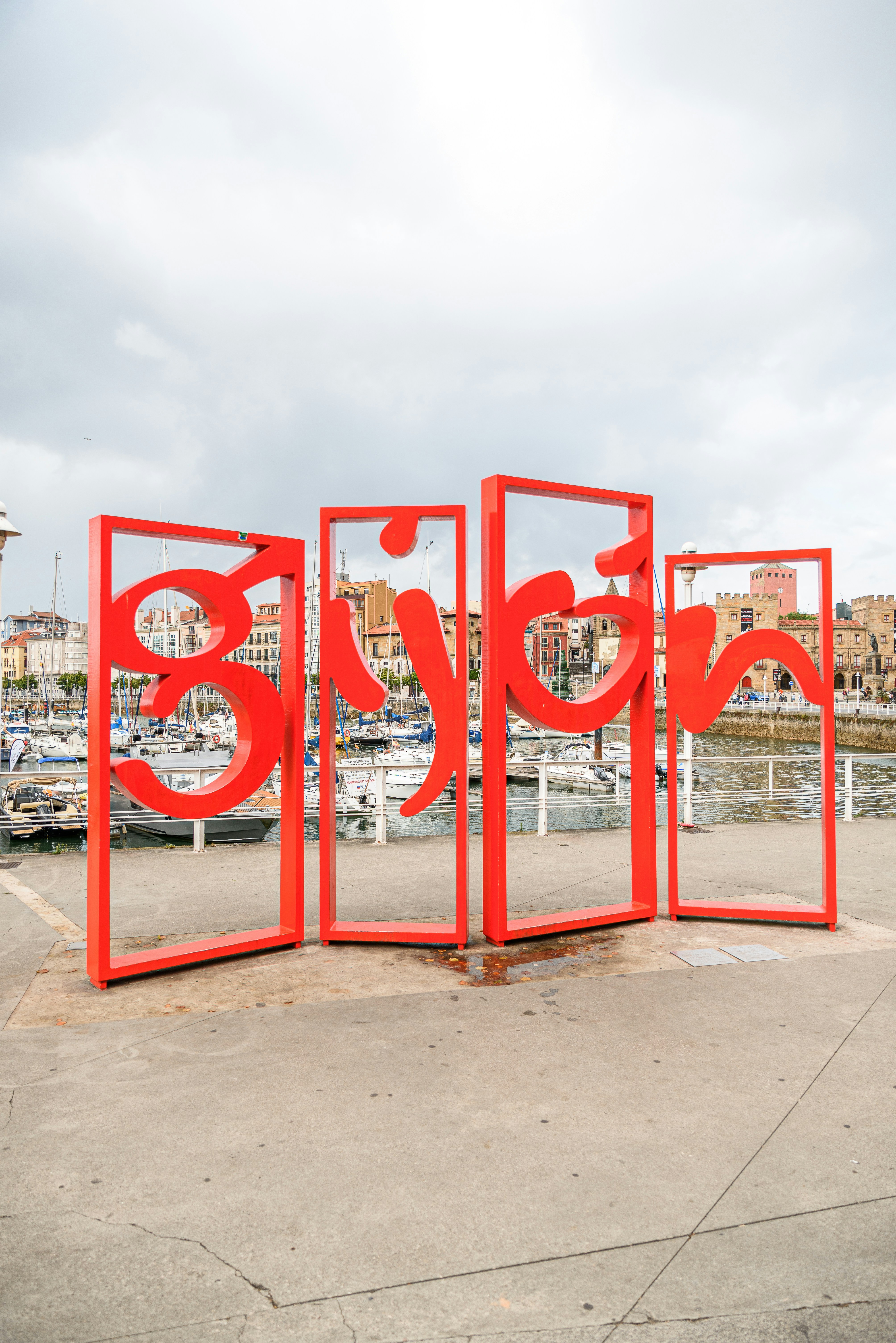 A group of red doors sitting on top of a cement ground