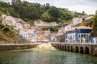 A river running through a small town next to a hillside