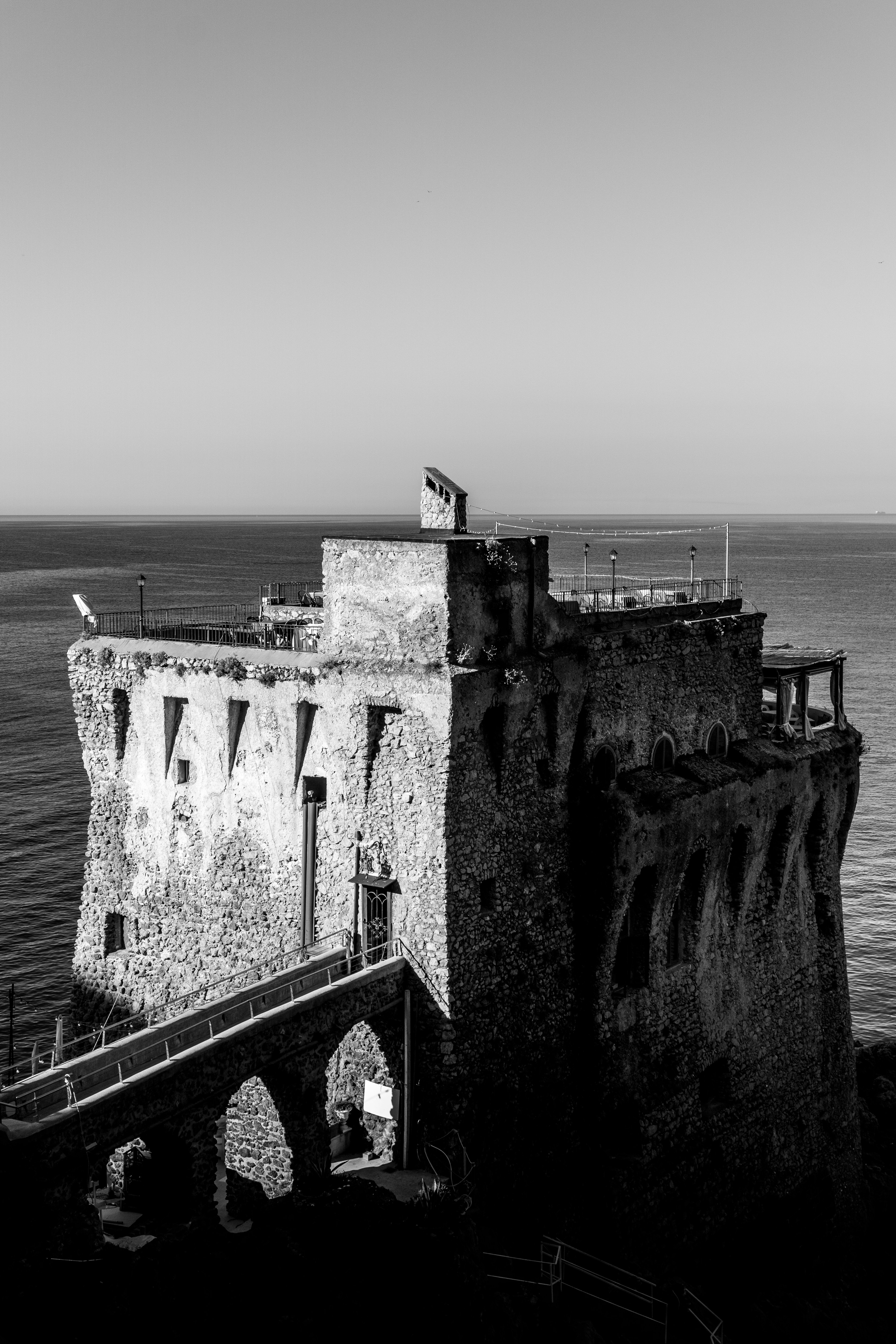 A black and white photo of a castle by the ocean