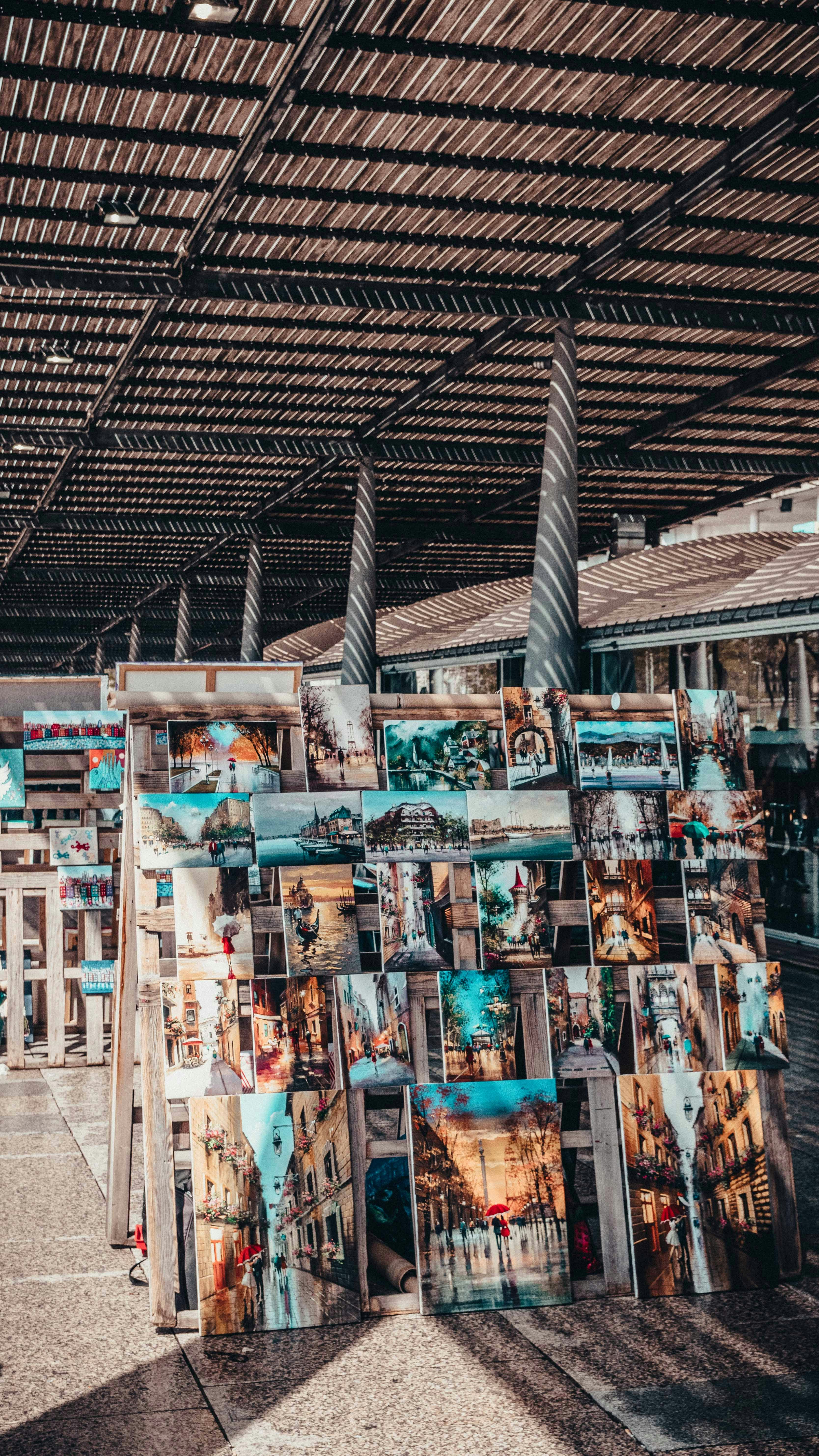 A bunch of pictures are stacked up in a room