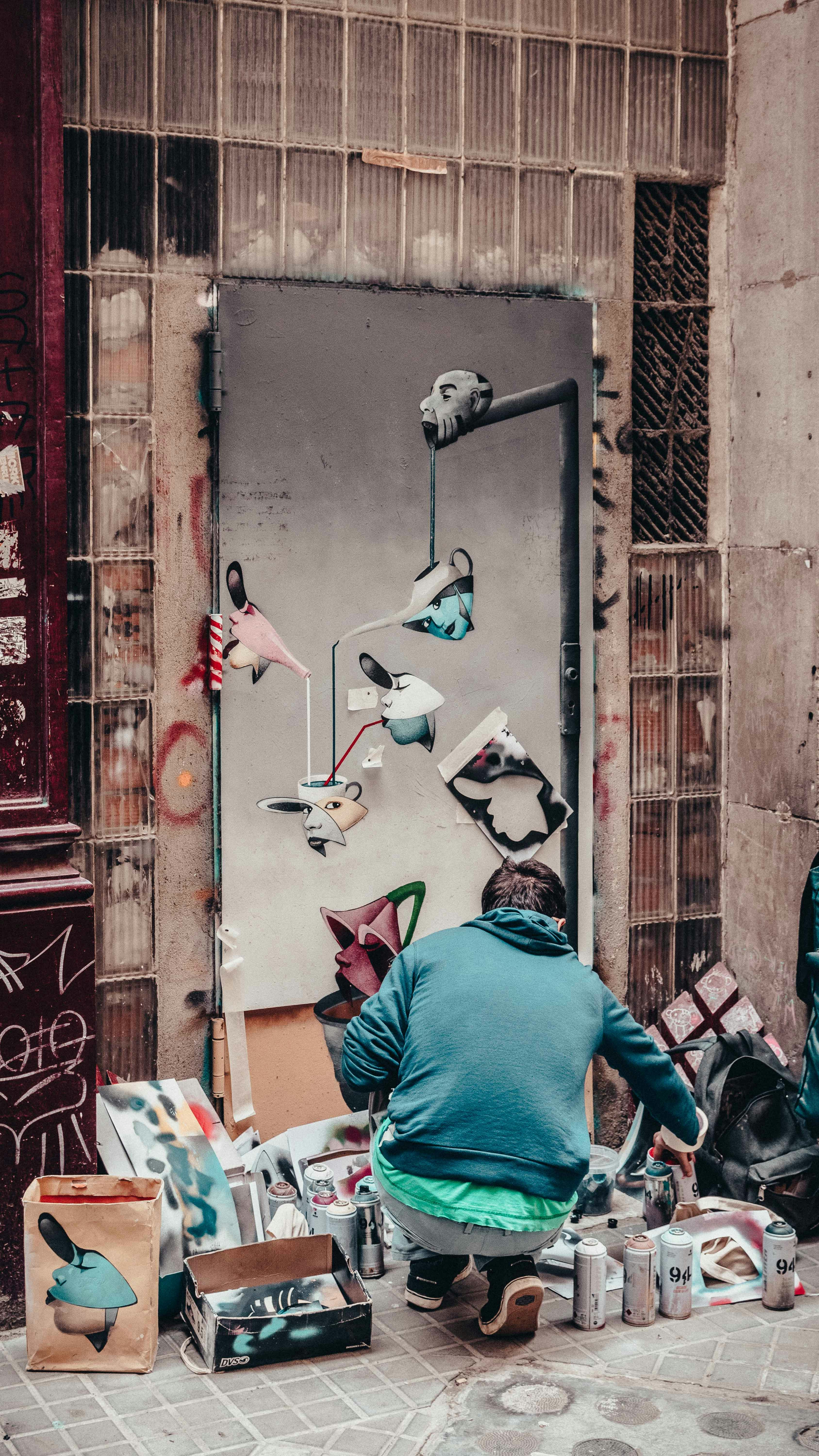 A man sitting on the ground working on a piece of art