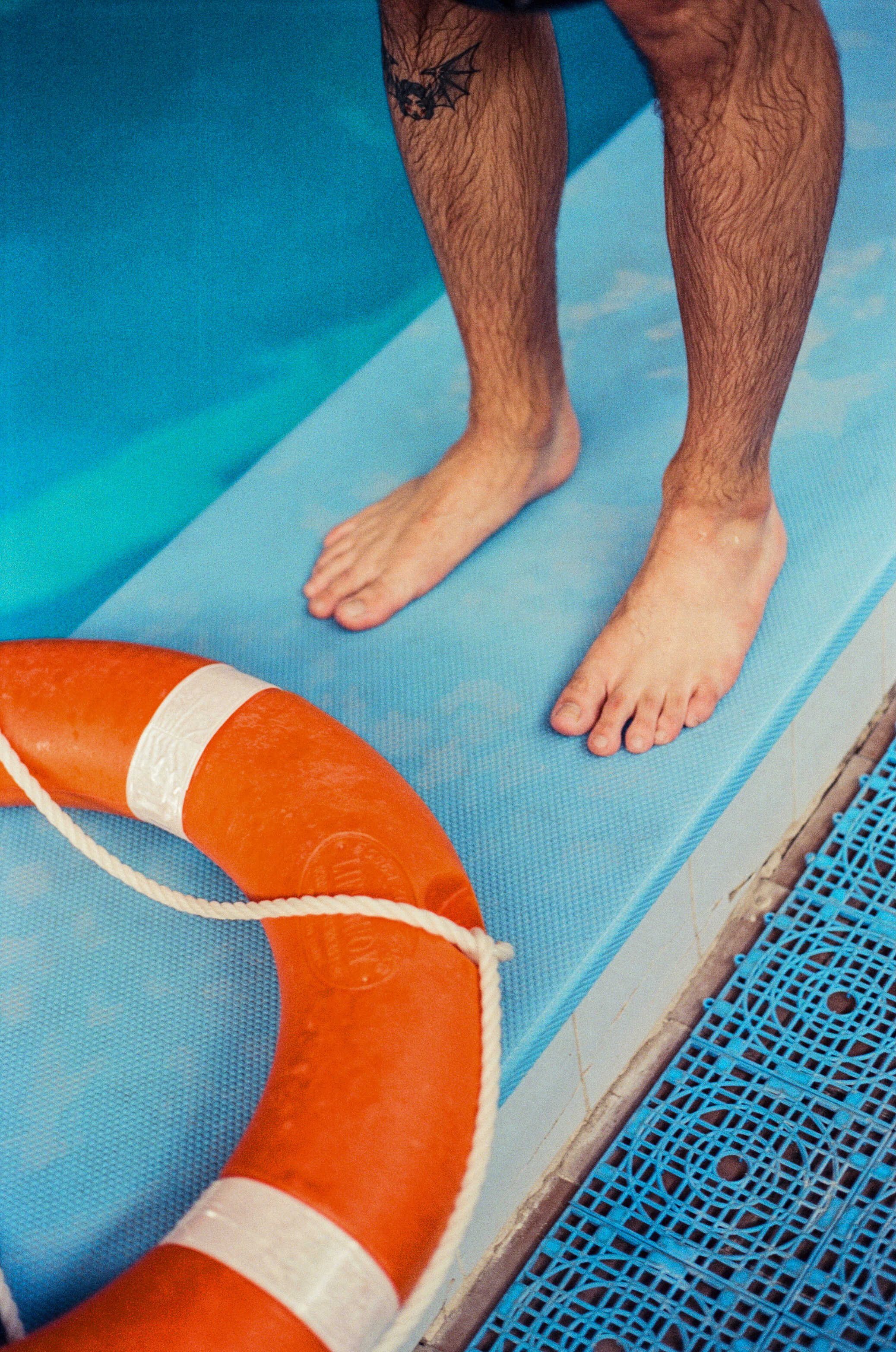 A man standing next to a life preserver in a swimming pool