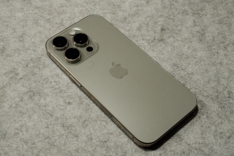 A silver iPhone sitting on top of a table