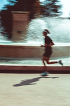 A man running down a street next to a fountain