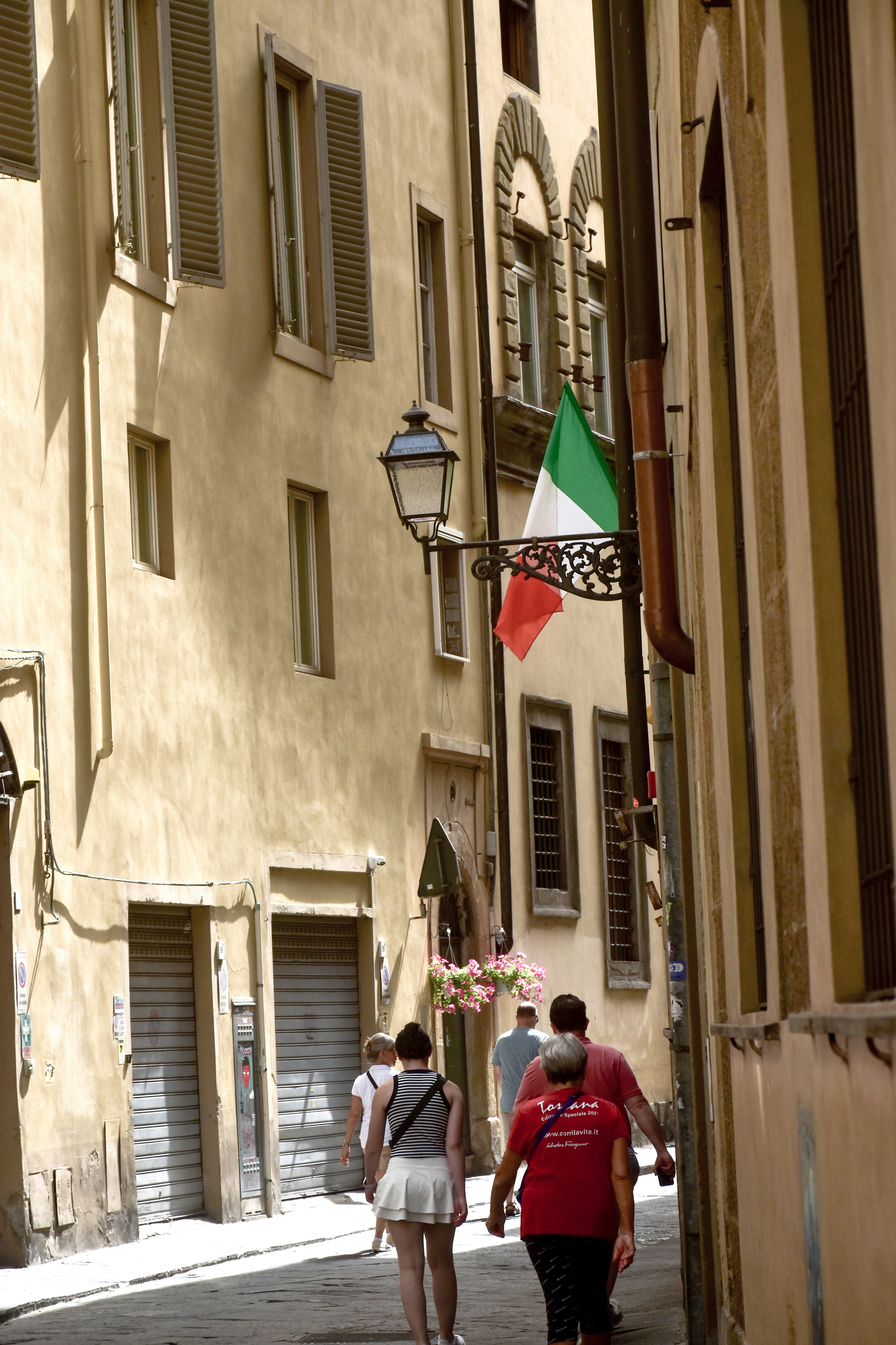 Un groupe de personnes marchant dans une rue à côté de grands immeubles