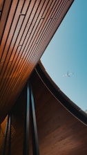 An airplane is flying over a wooden structure