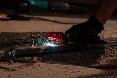 A person using a grinder on a piece of metal