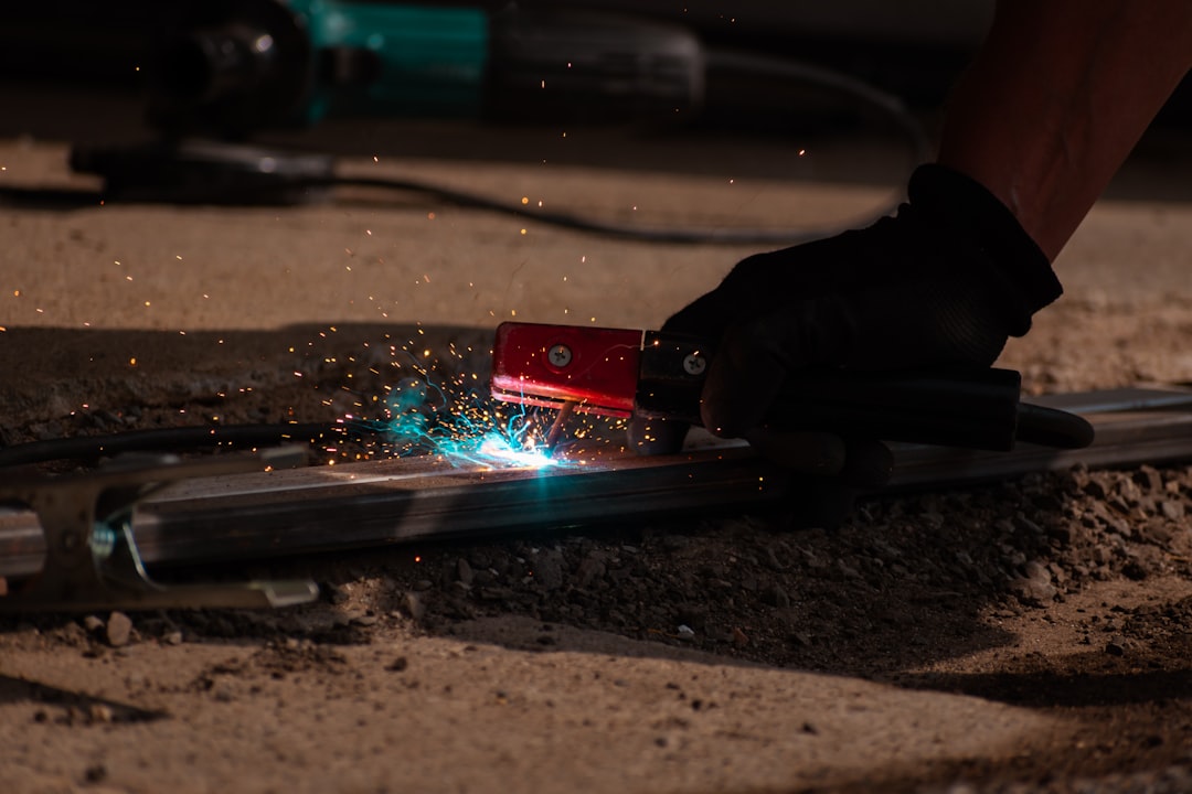 A person using a grinder on a piece of metal,
