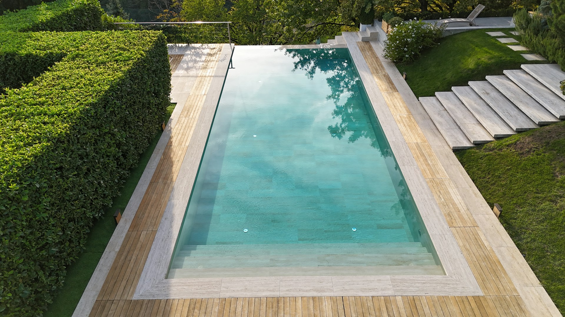 An aerial view of a pool surrounded by hedges