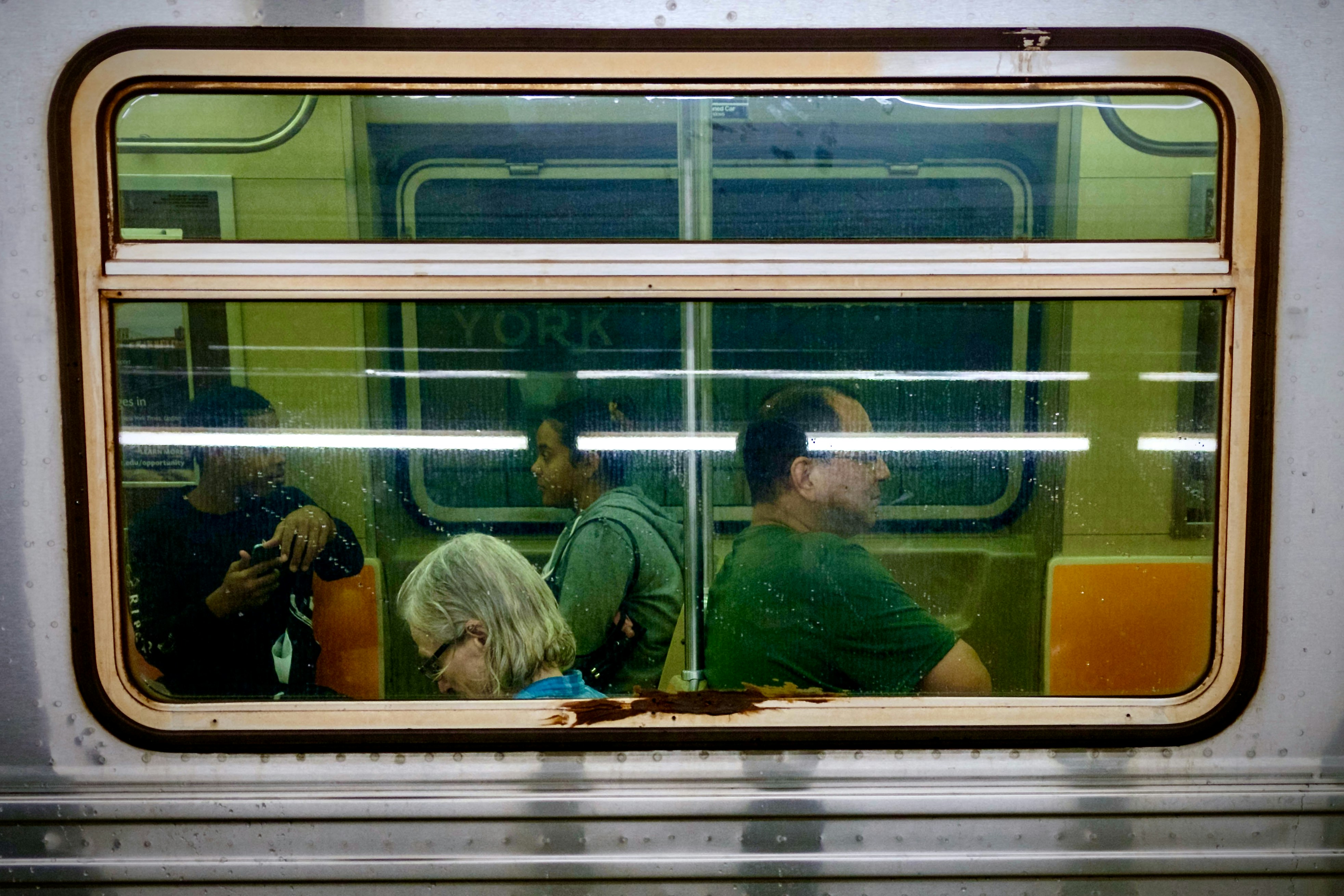 Eine Gruppe von Menschen, die in einem Zug nebeneinander sitzen