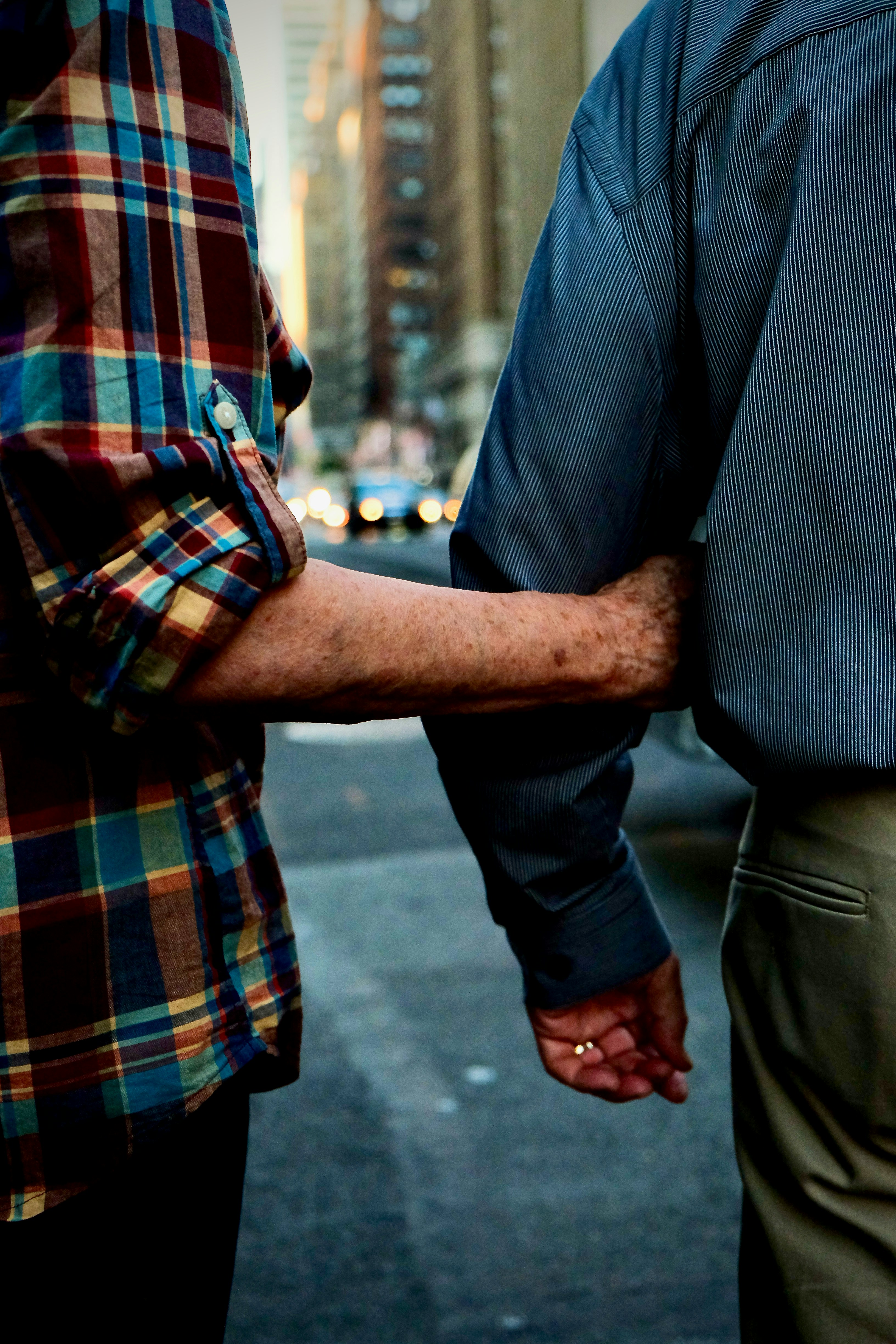 Ein Mann und eine Frau, die sich an den Händen halten, auf einer Straße in der Stadt