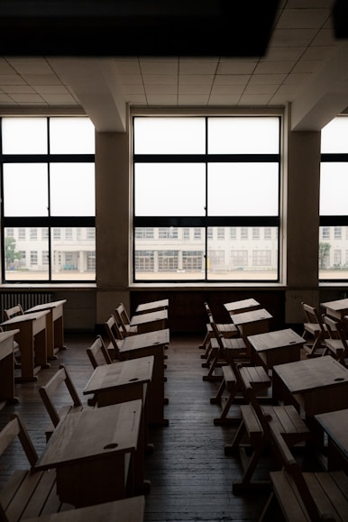 An empty classroom with desks and windows
