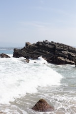 A rocky beach with waves crashing against the rocks