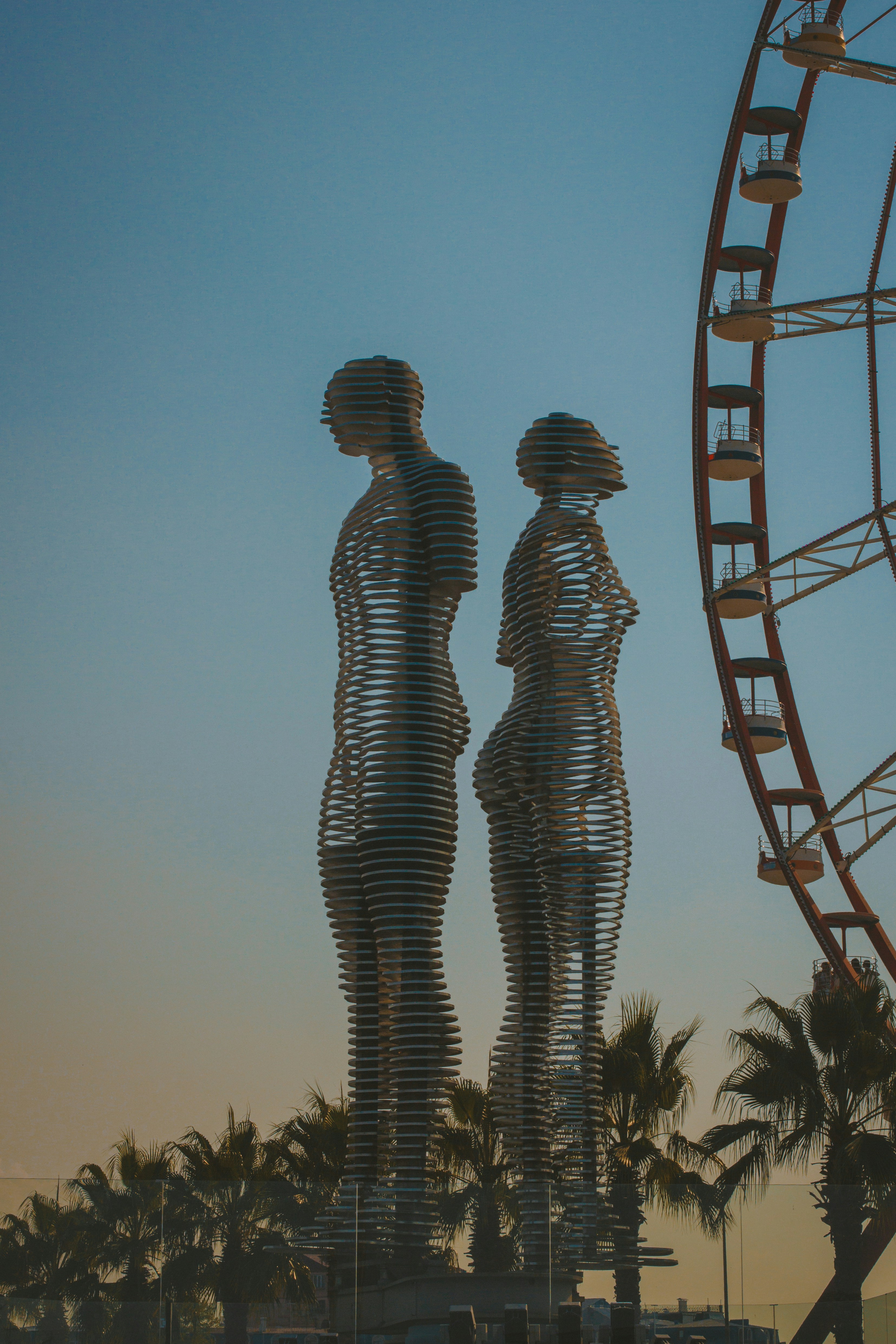 A ferris wheel and a statue in front of a ferris wheel