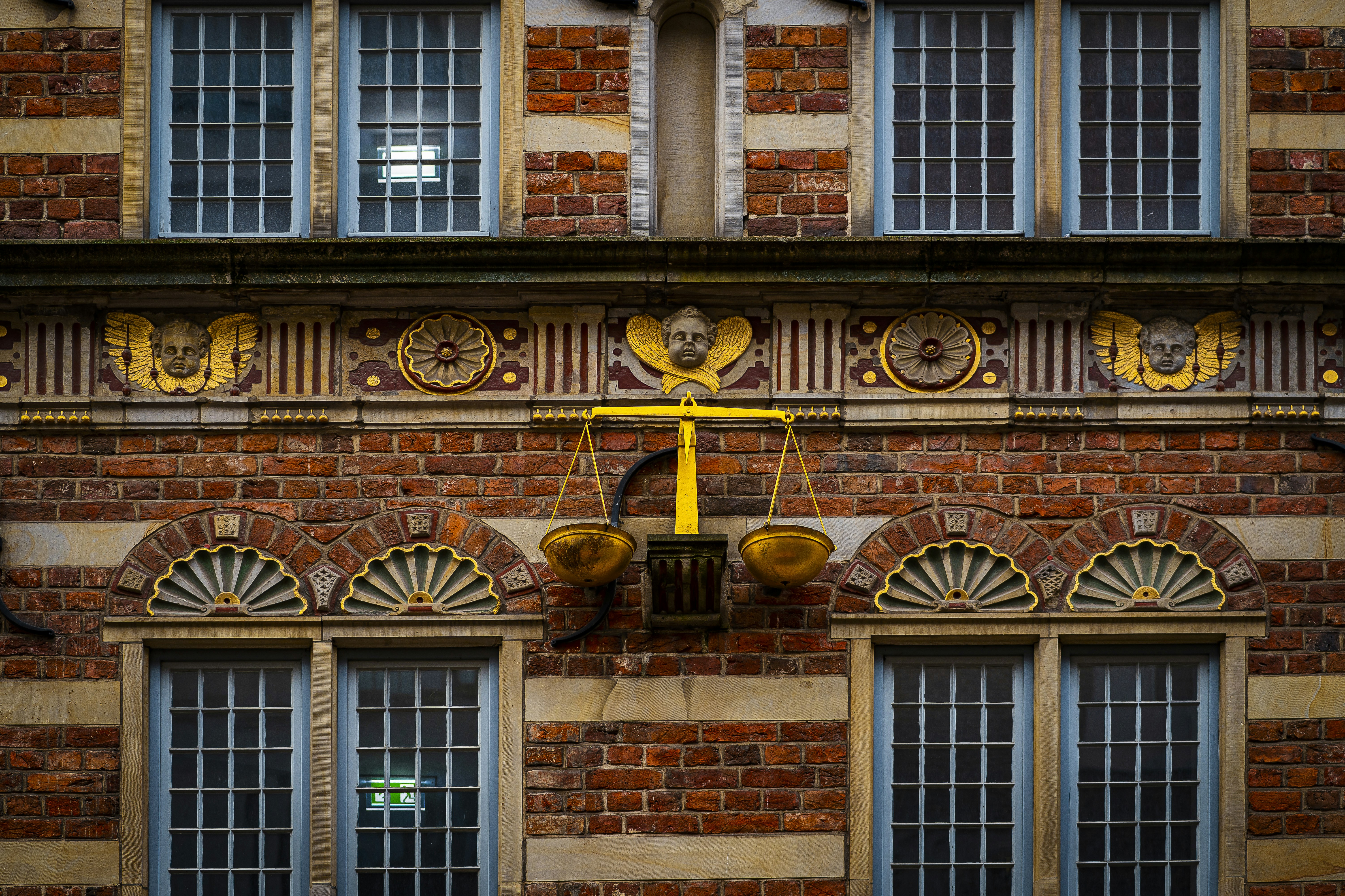 A brick building with a scale on the front of it
