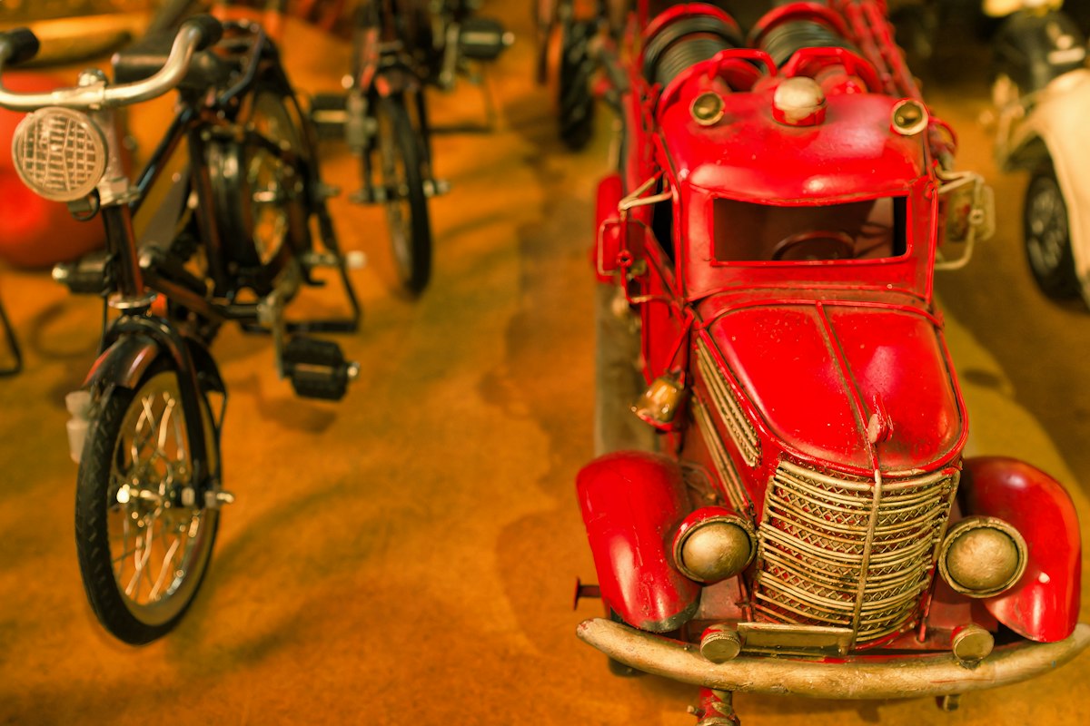 A red toy car on a wooden floor