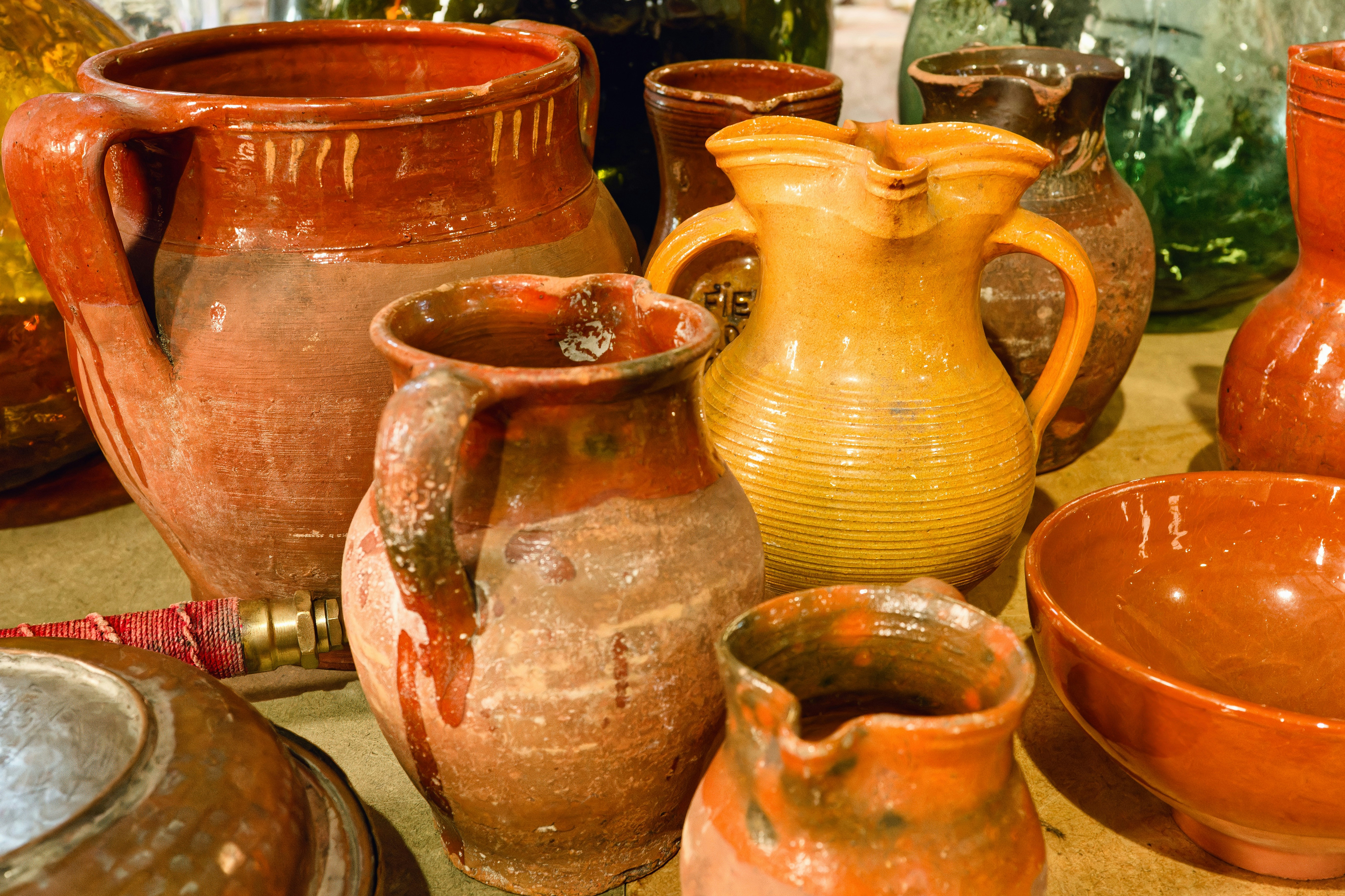 A table topped with lots of different colored vases