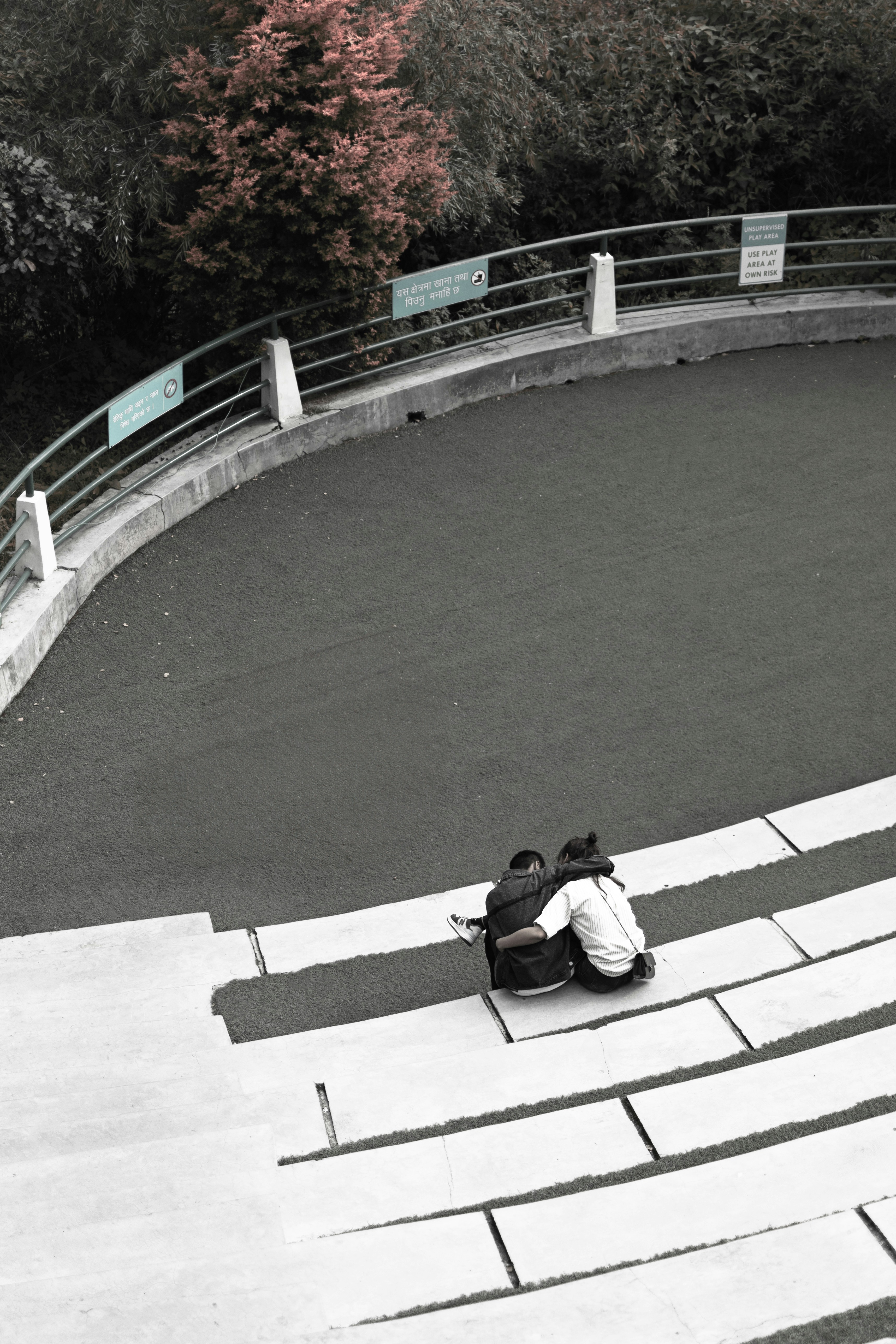 A person sitting on a skateboard in a skate park