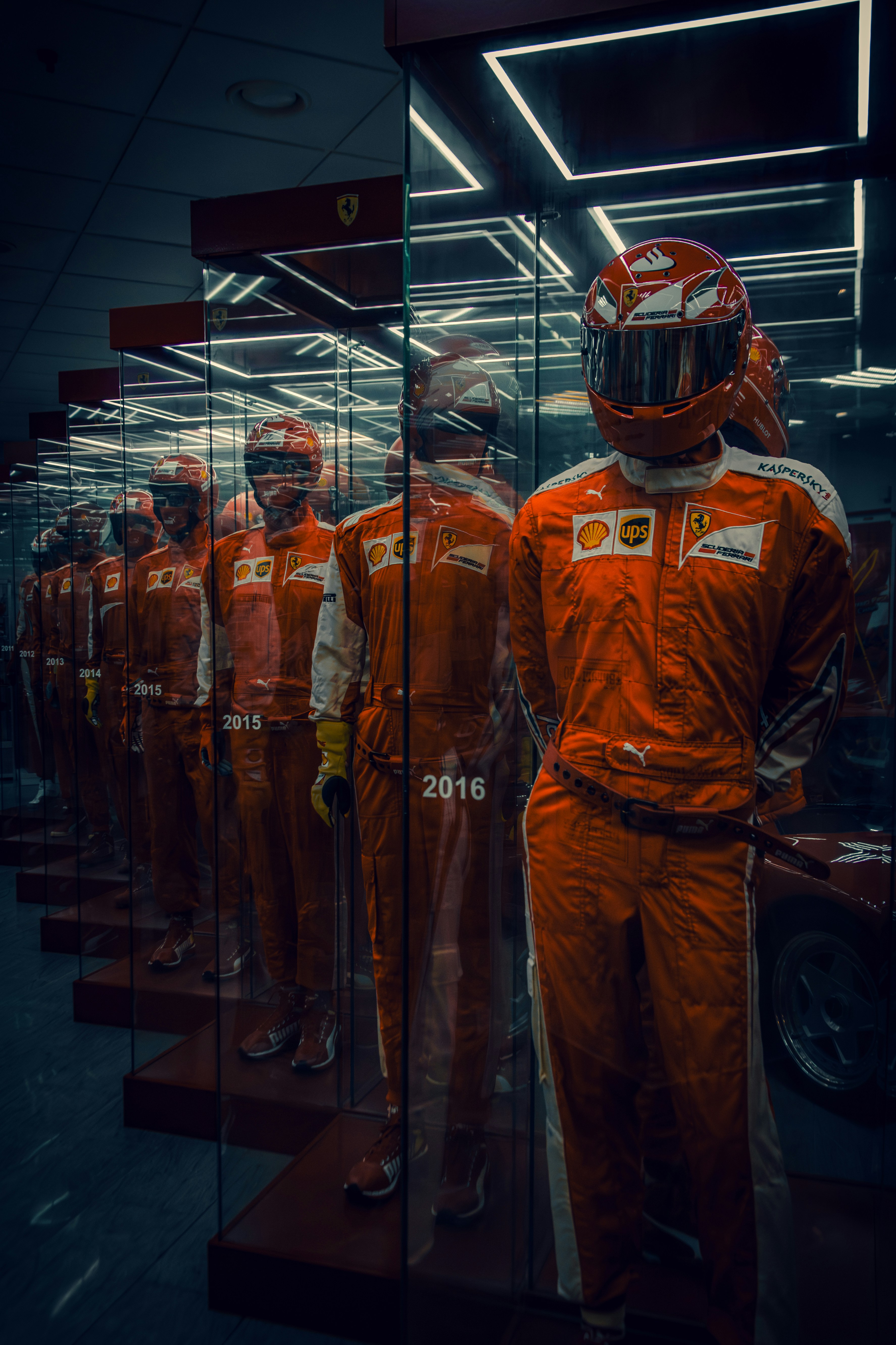 Formula 1 racing suit and helmet on dark carbon fiber surface with dramatic side lighting