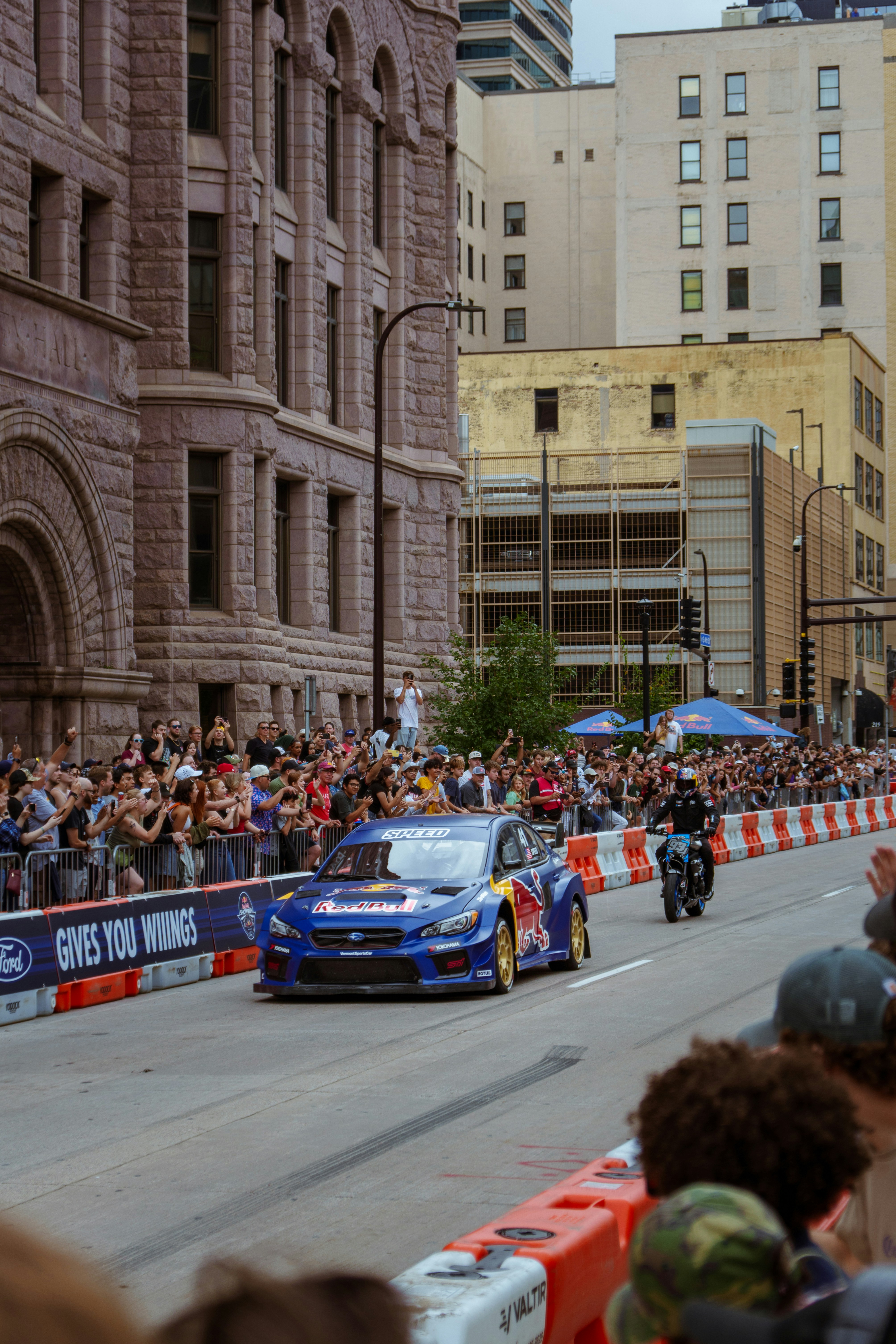 A group of people watching a race on a city street