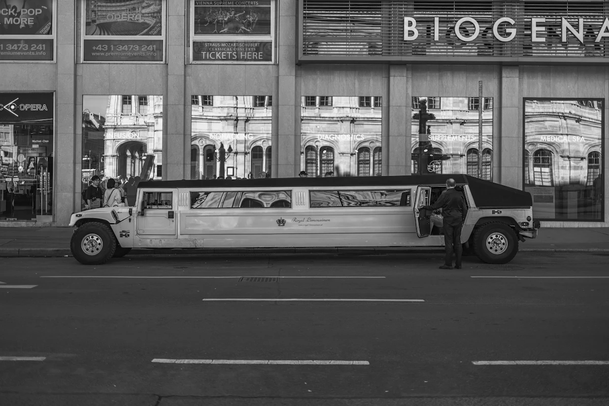 A dark executive shuttle van parked in front of a building