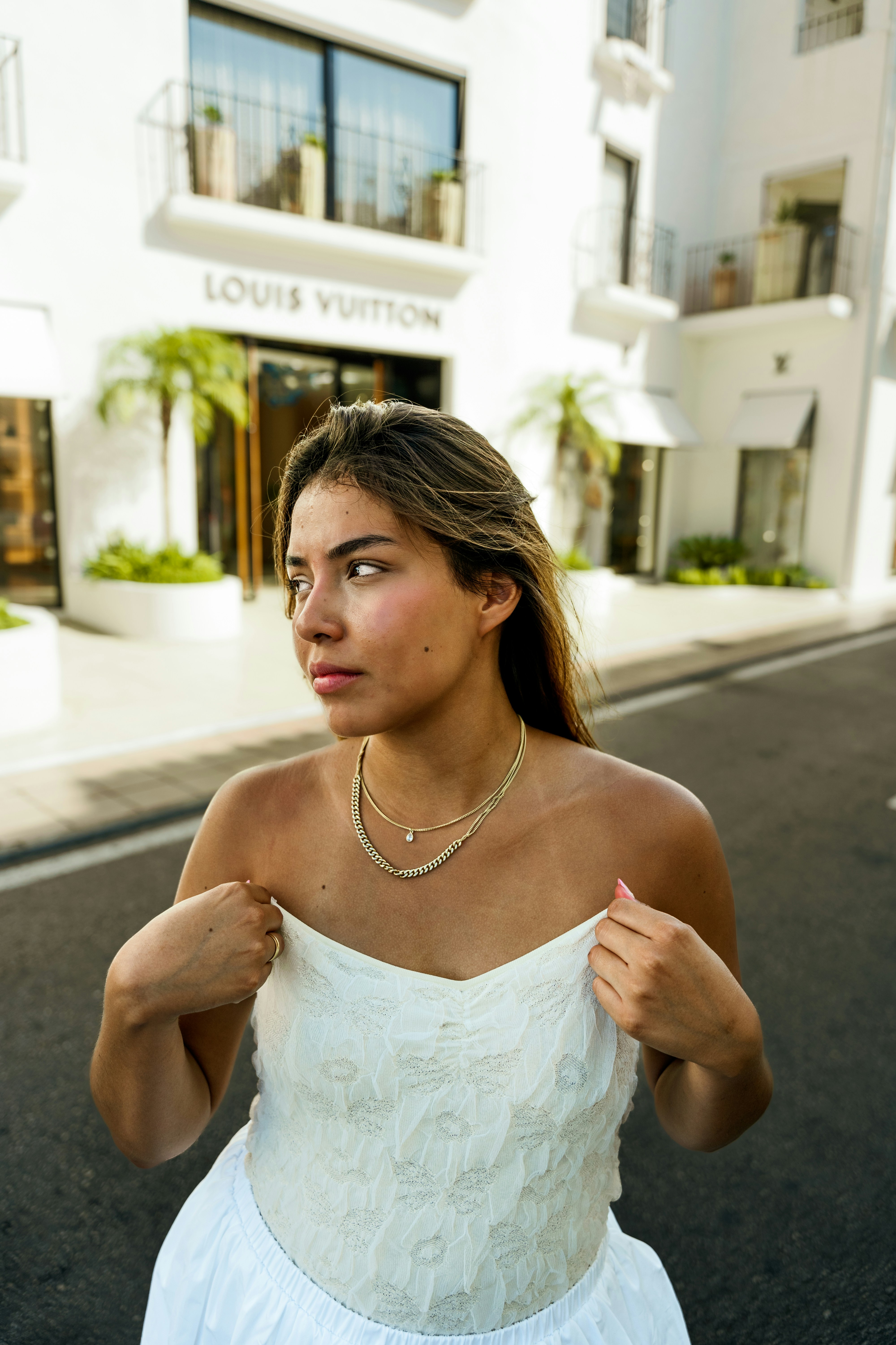 A woman in a white dress walking down a street