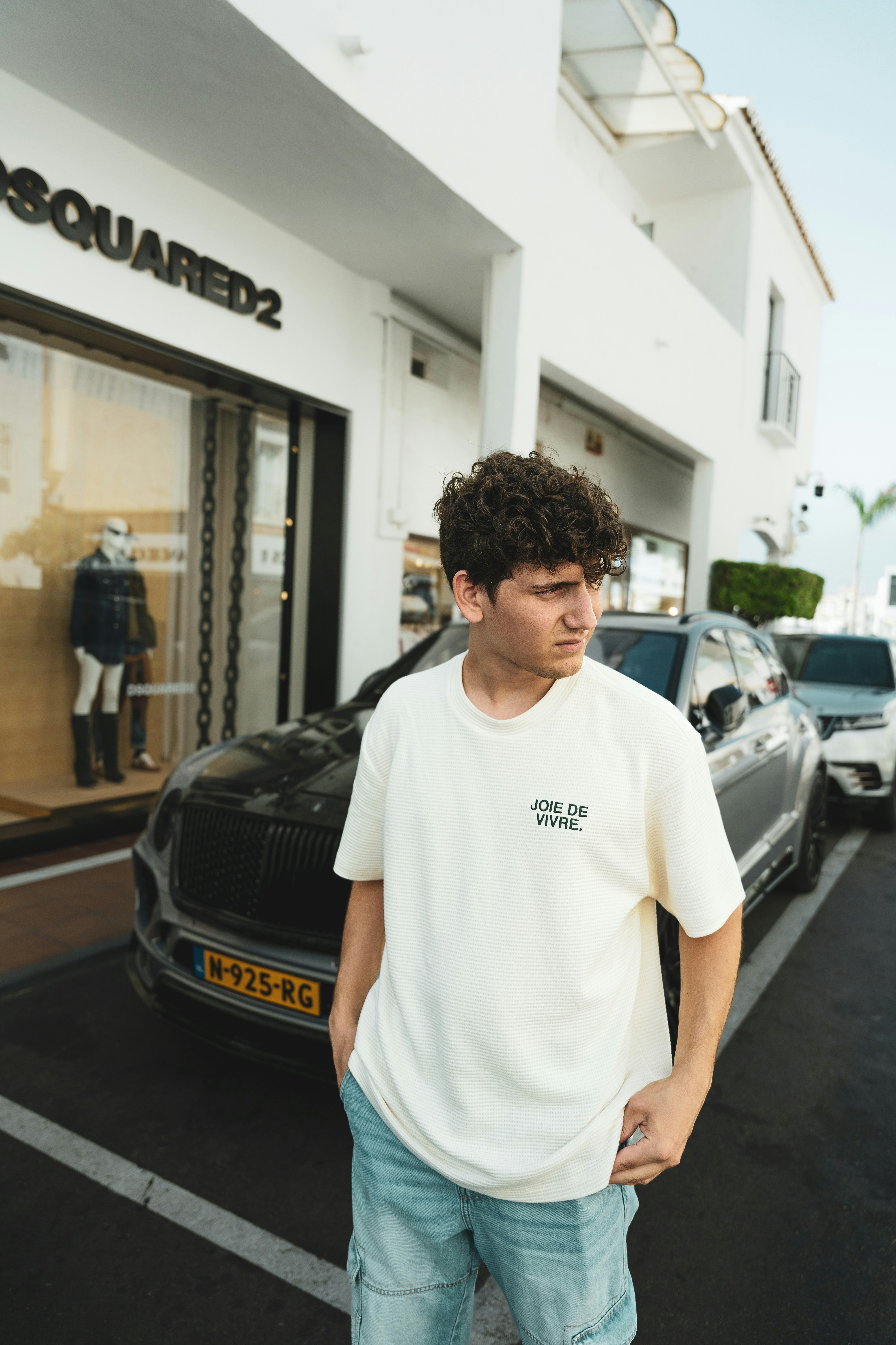 A young man standing in front of a store