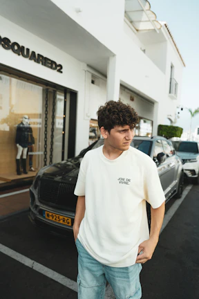A young man standing in front of a store