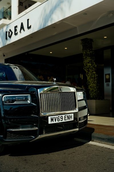 A black rolls royce parked in front of a hotel