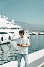 A man standing on a dock next to a boat