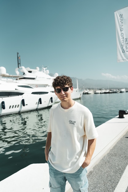 A man standing on a dock next to a boat
