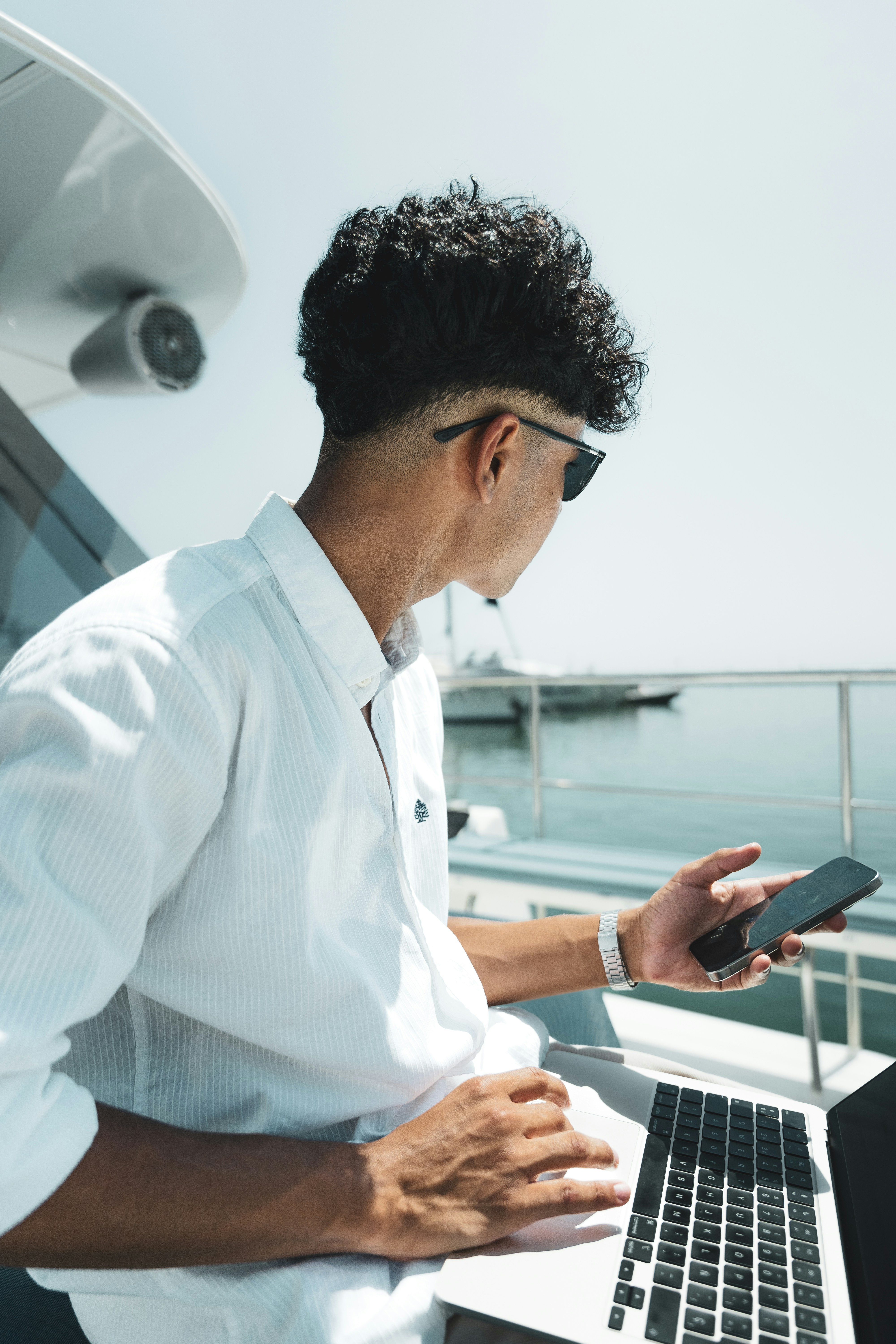 A man on a boat looking at his cell phone