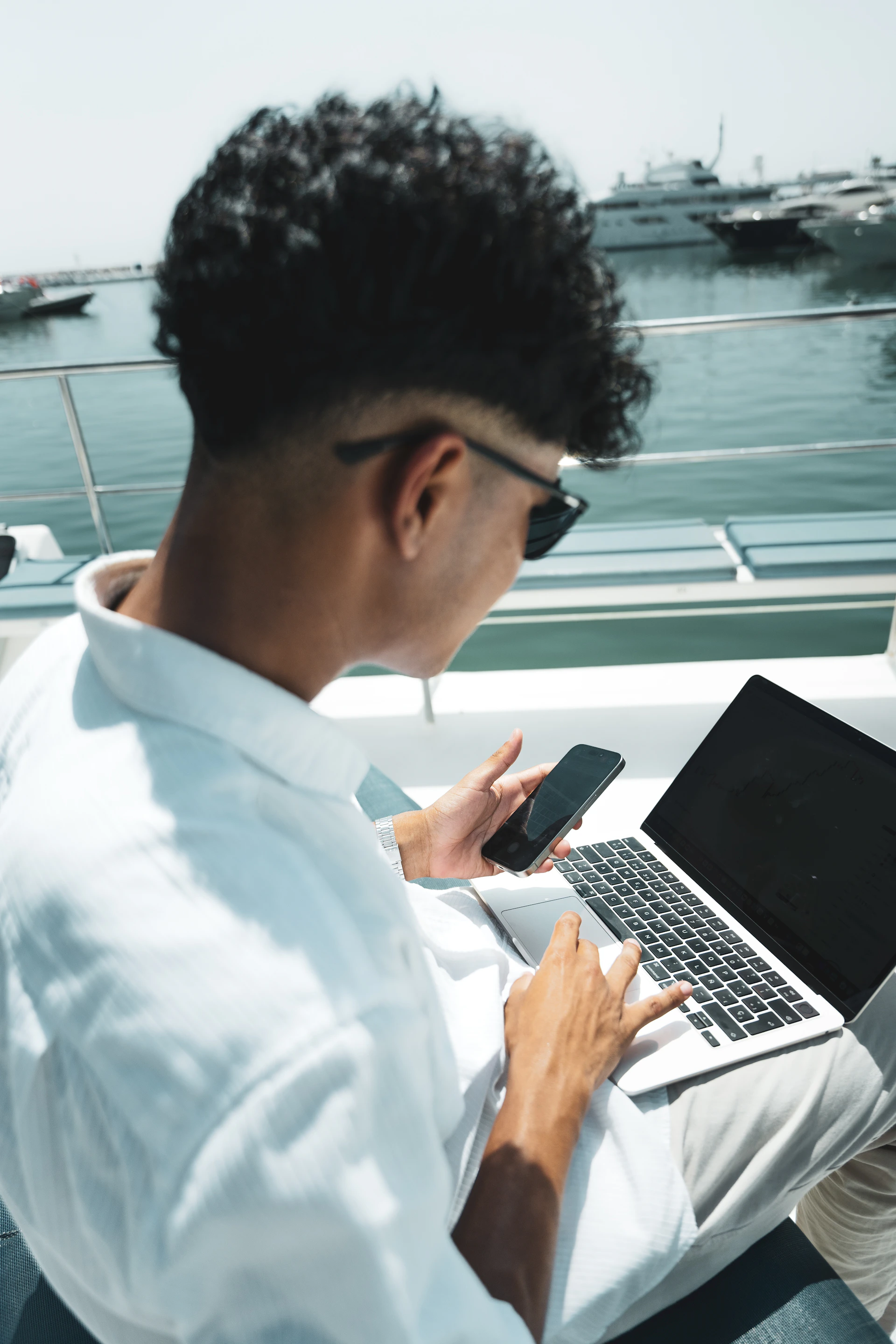 A man sitting on a bench using a laptop computer