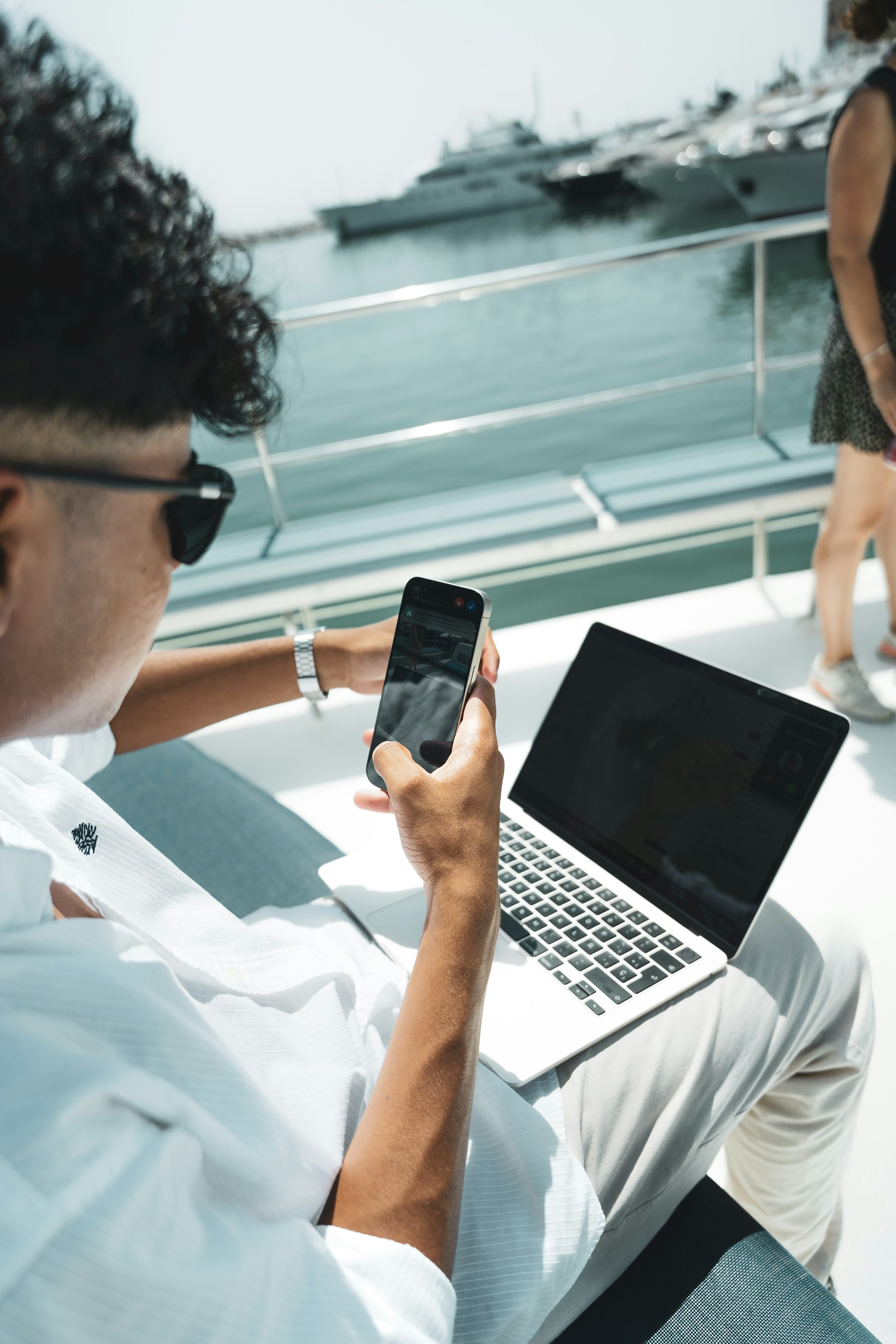 A man sitting on a boat using a cell phone