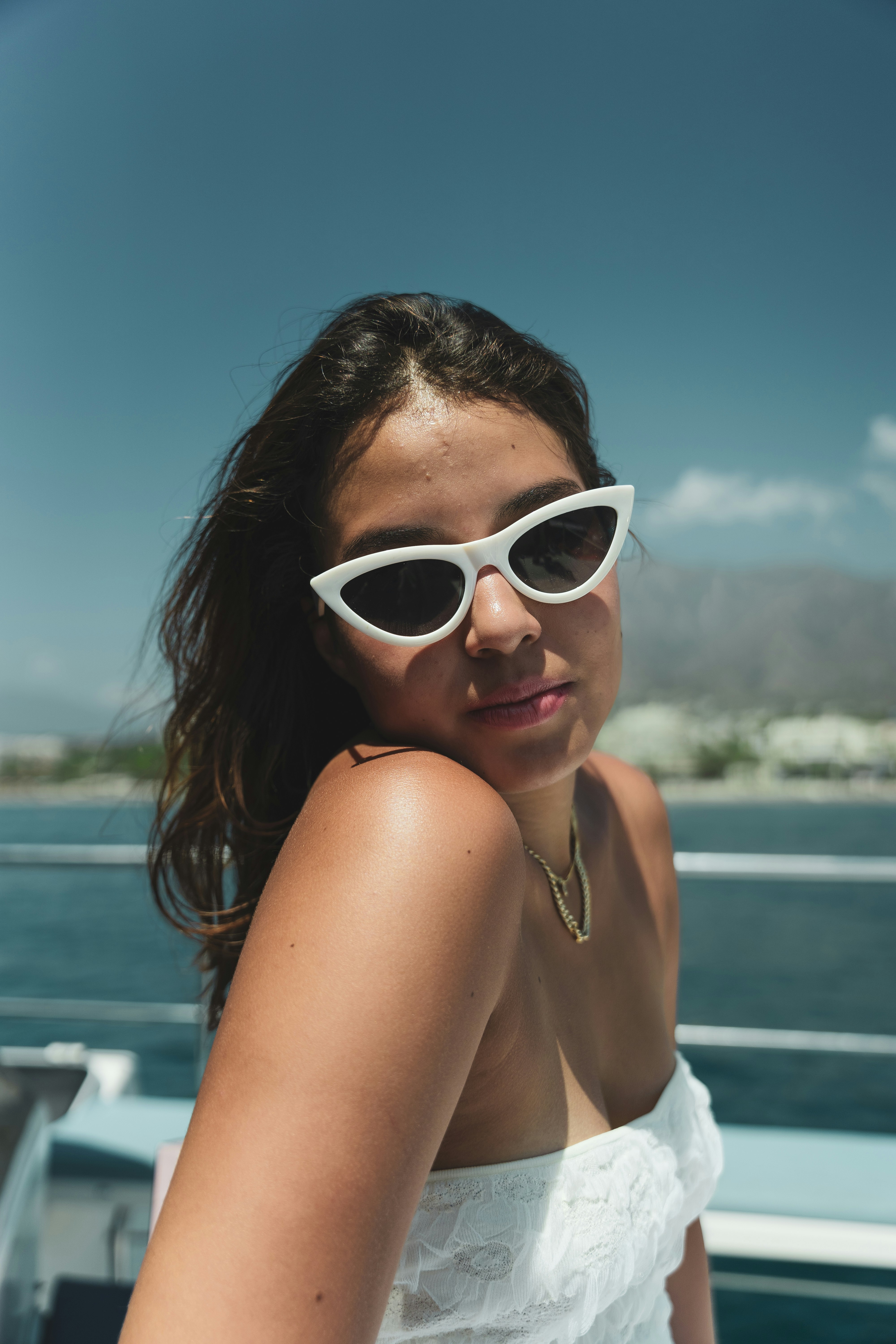 A woman wearing white sunglasses on a boat