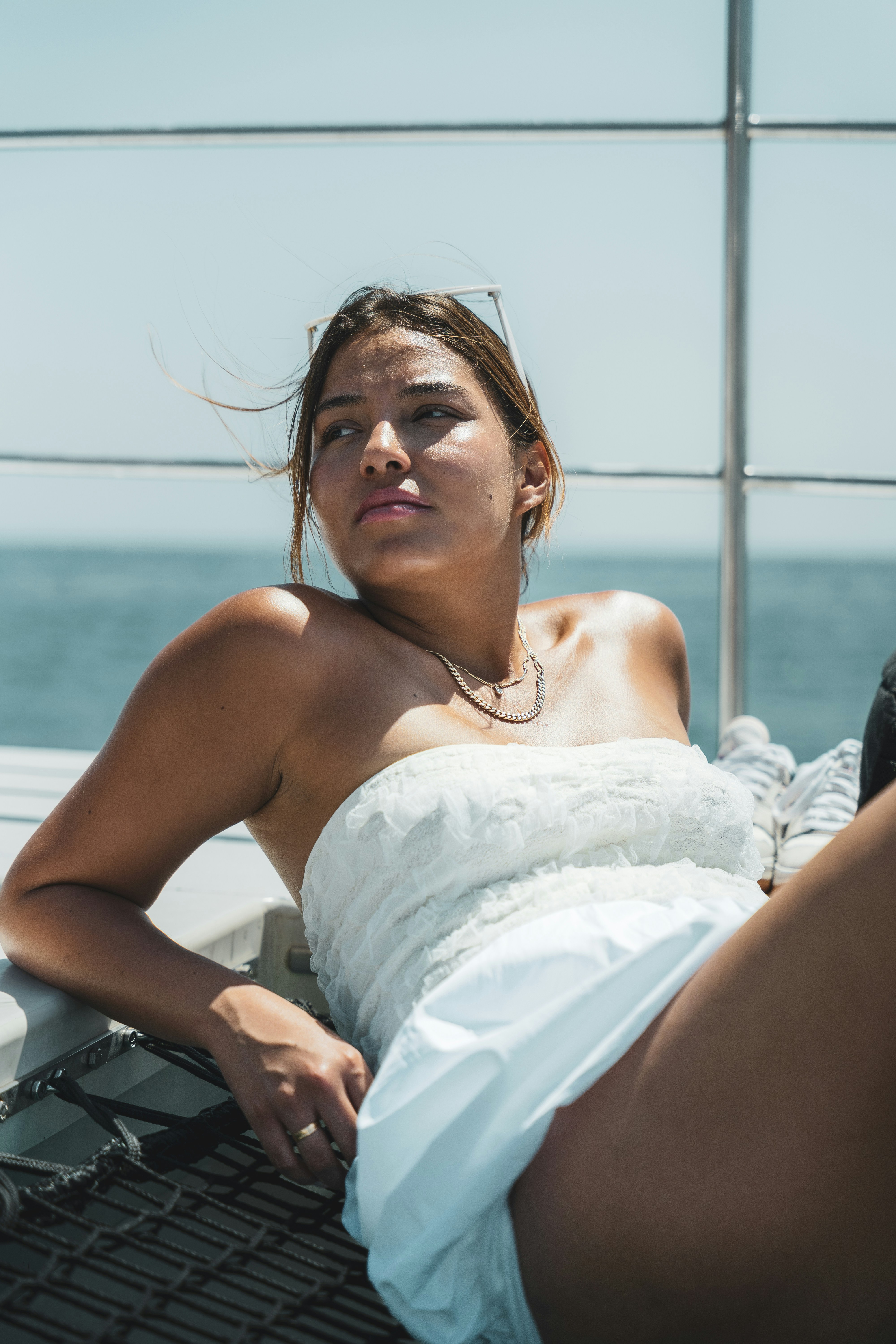 A woman in a white dress laying on a boat