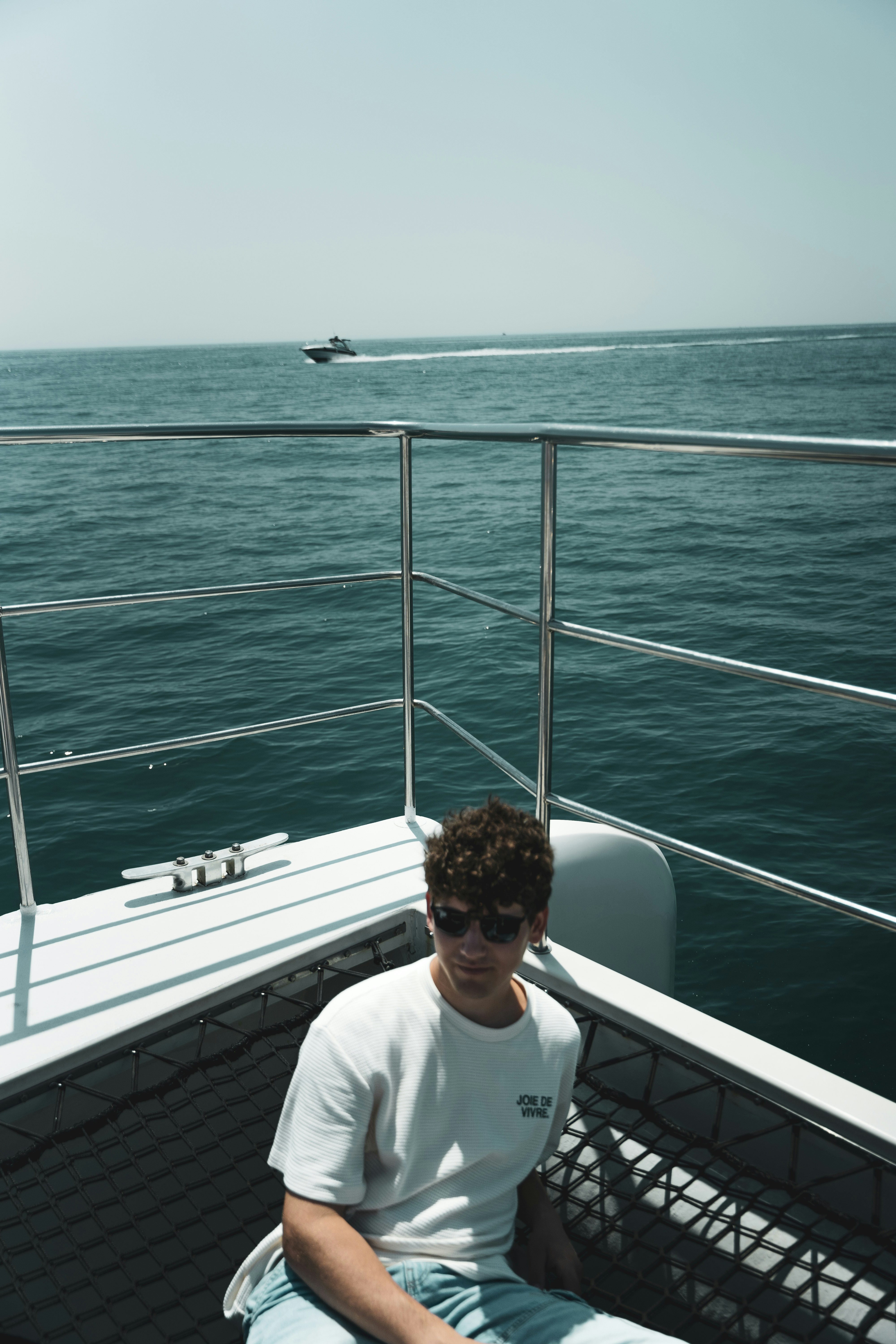 A man sitting on the back of a boat in the ocean