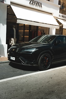 A black sports car parked in front of a building