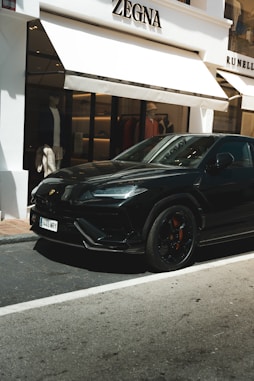 A black sports car parked in front of a building