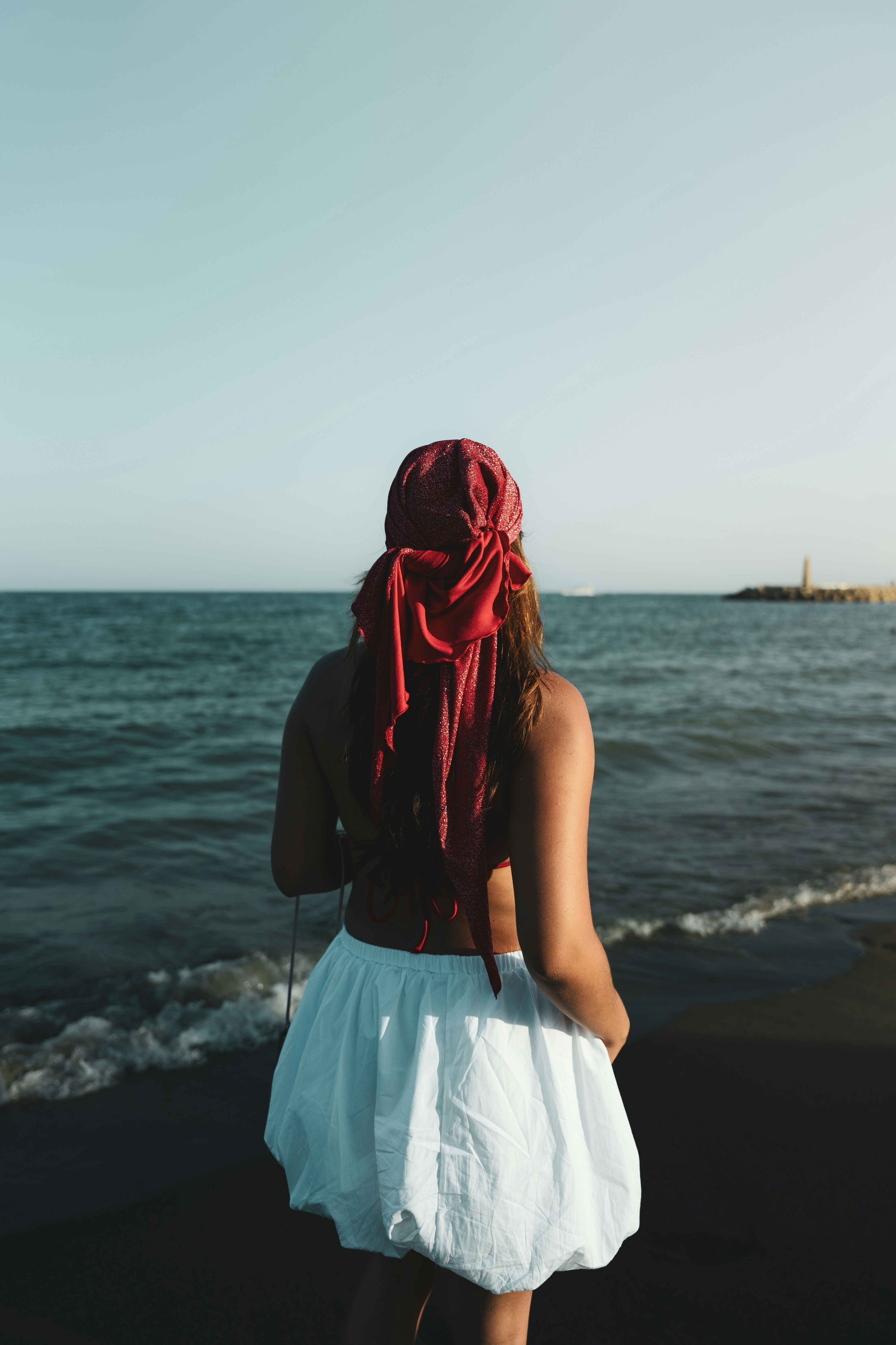A woman standing on a beach next to the ocean
