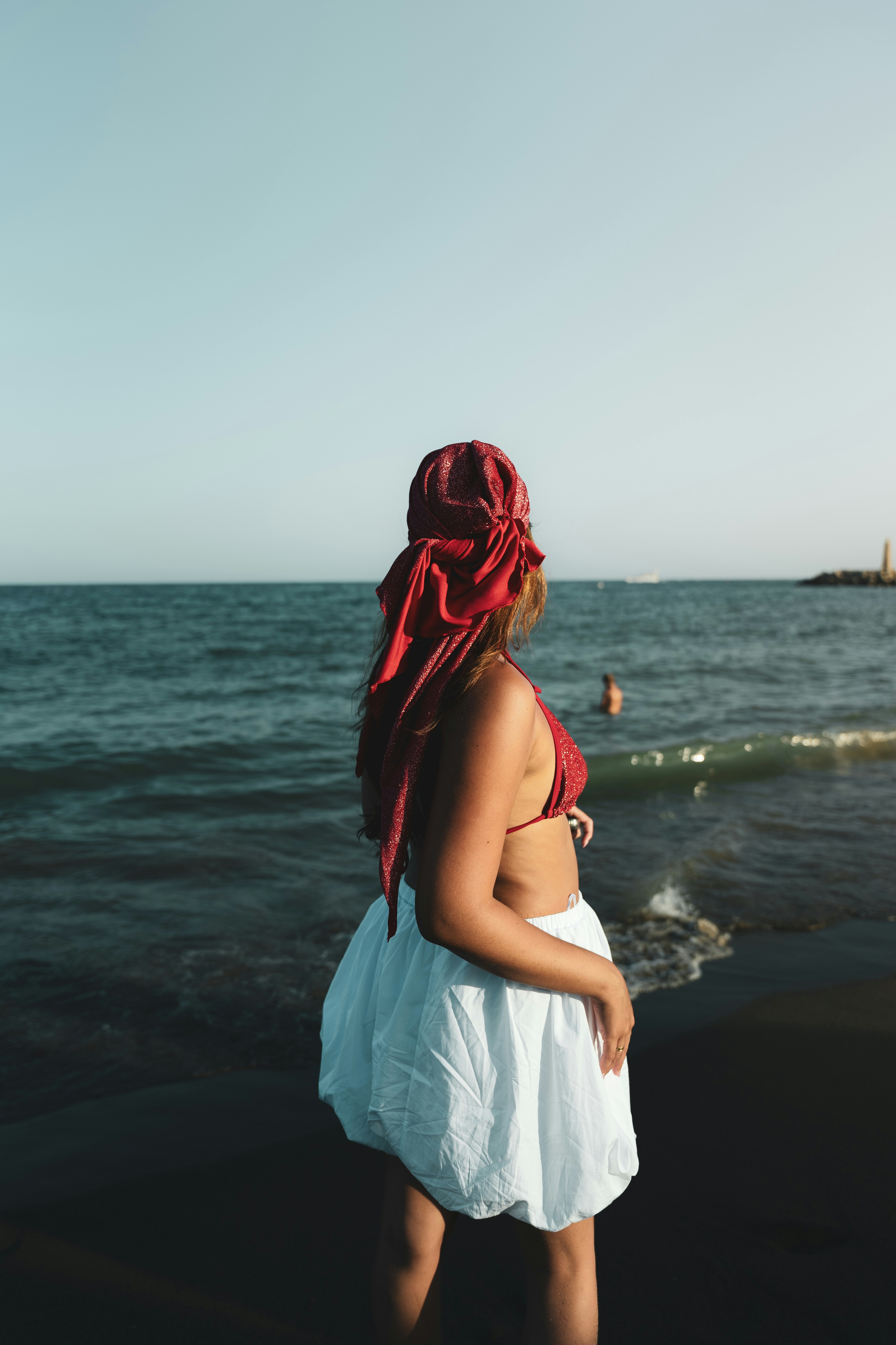 A woman standing on a beach next to the ocean