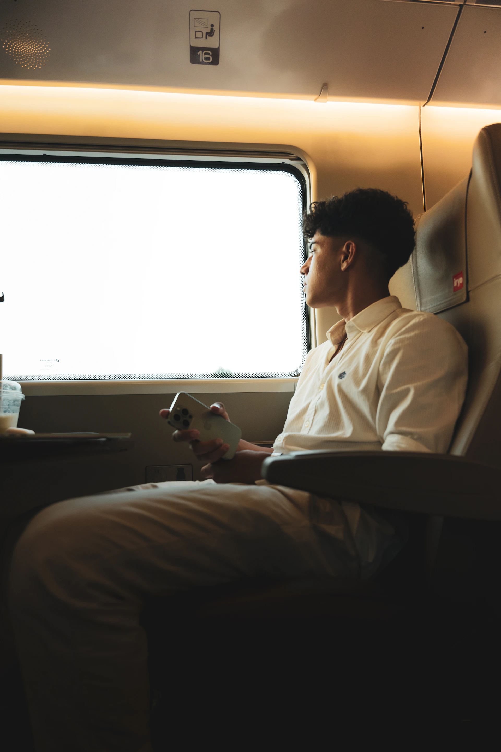 A man sitting on a train looking out the window