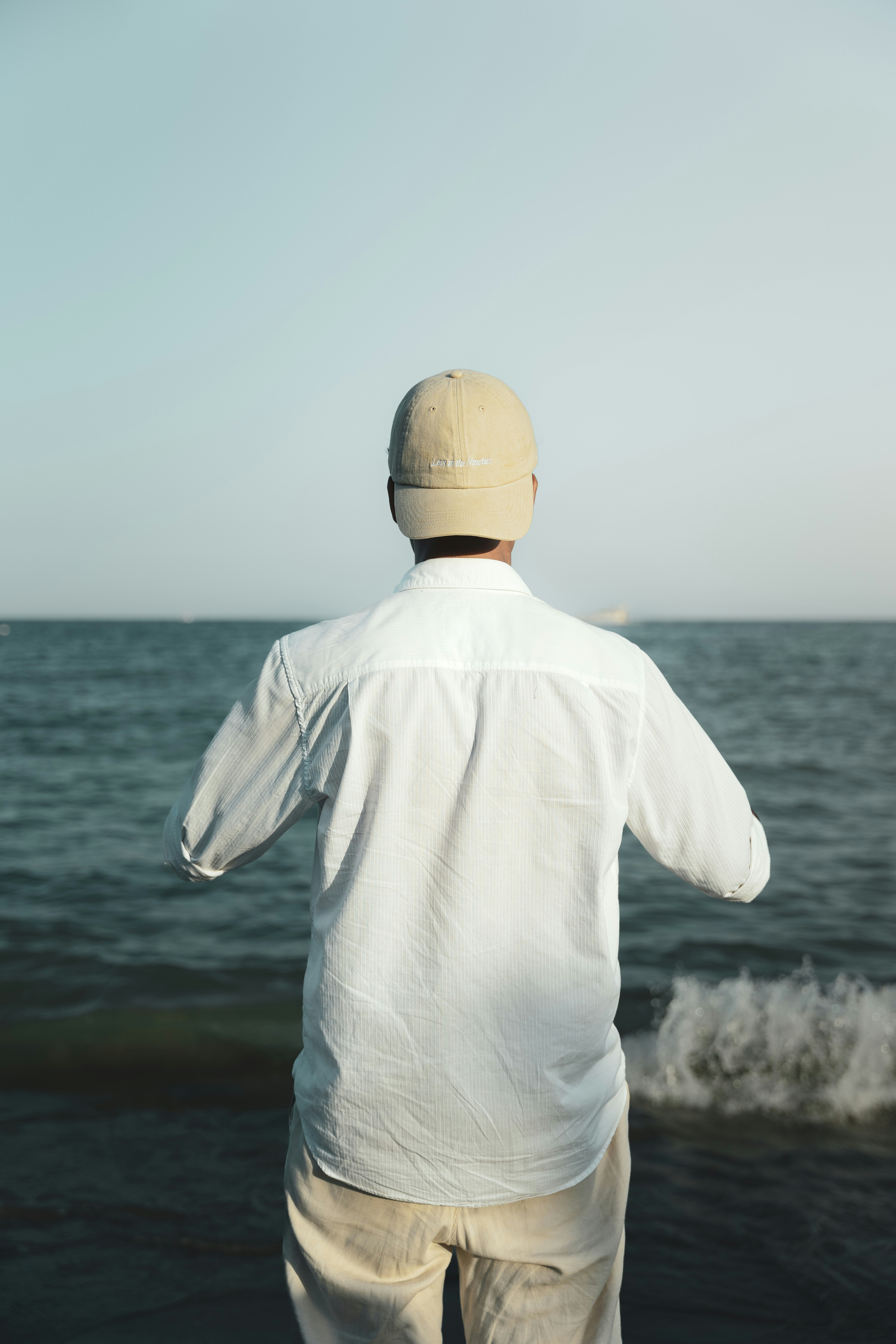 A man standing on a beach near the ocean