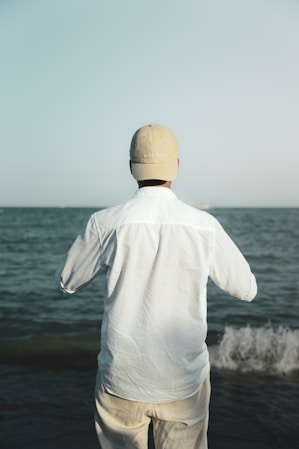 A man standing on a beach near the ocean