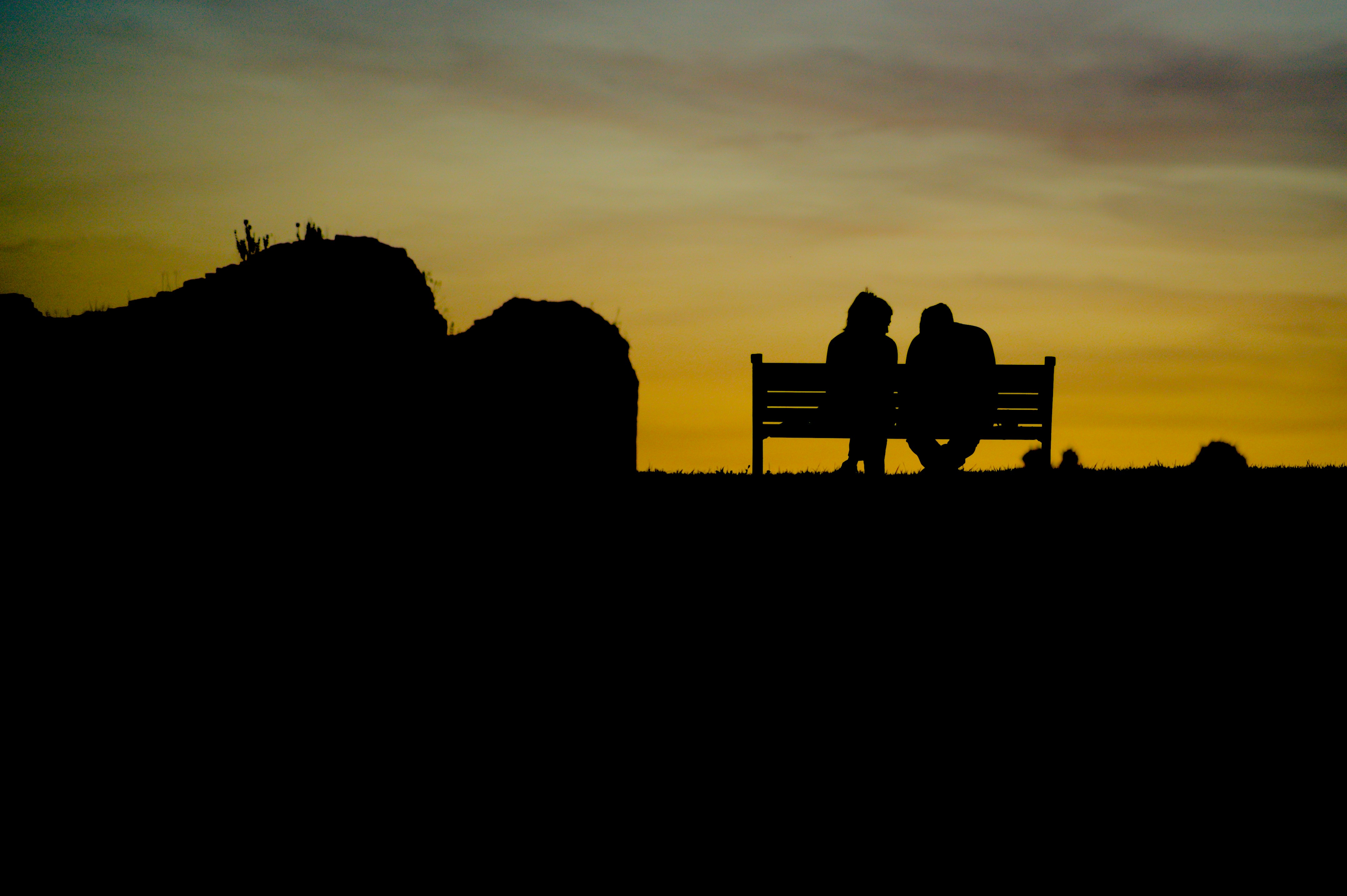 A young couple sharing a deeply emotional and joyful moment outdoors at sunset, laughing with tears of happiness in their eyes, capturing a meaningful and cost-free romantic experience.